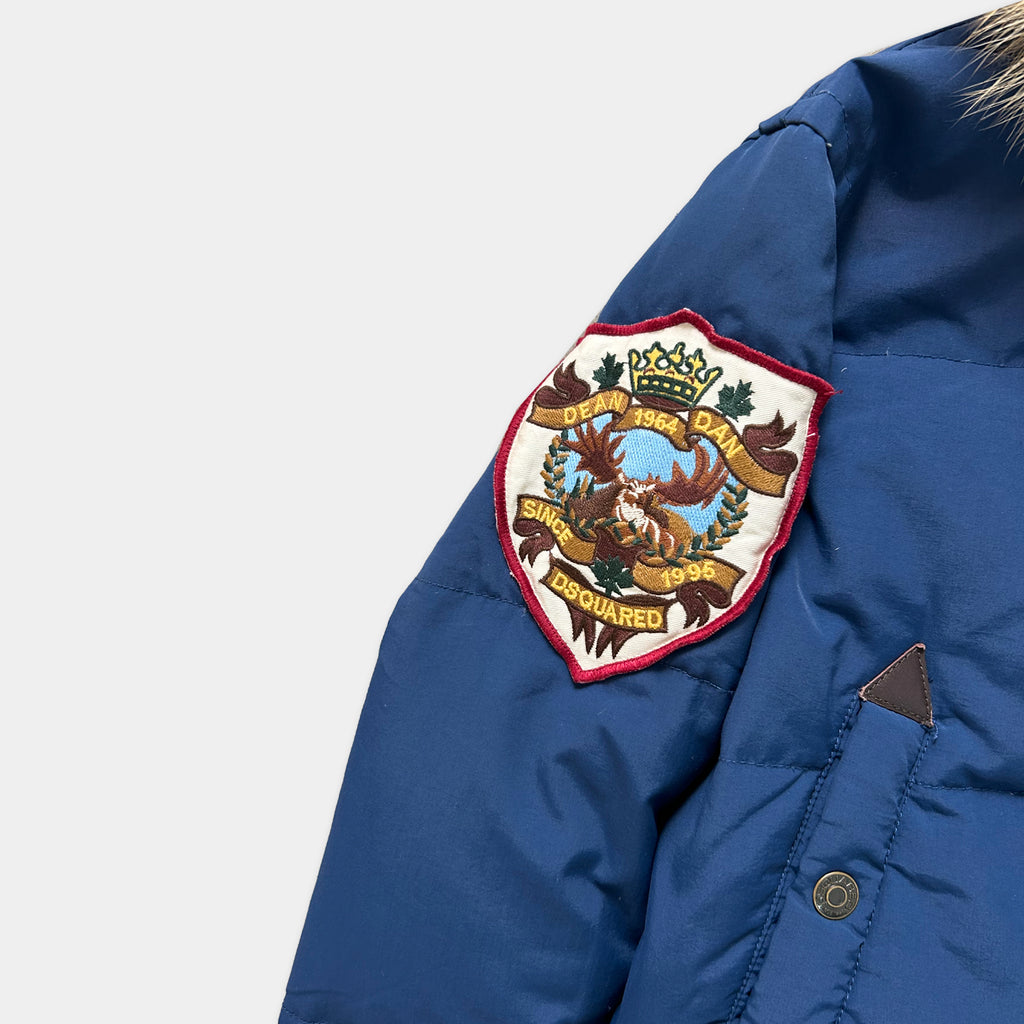 A close-up view of a blue jacket with a decorative patch on the left side of the chest.