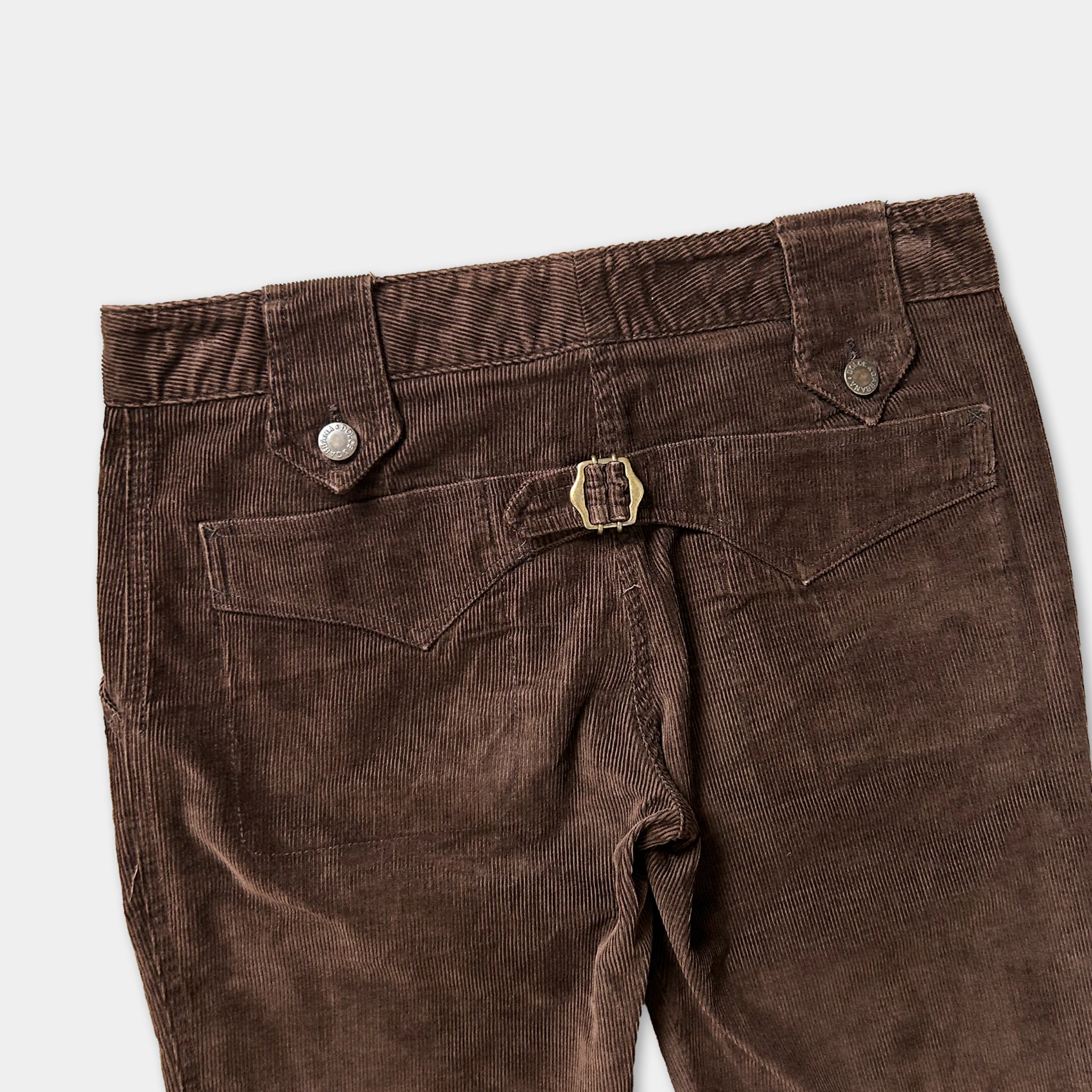 A pair of brown corduroy pants with a belt and button closure.