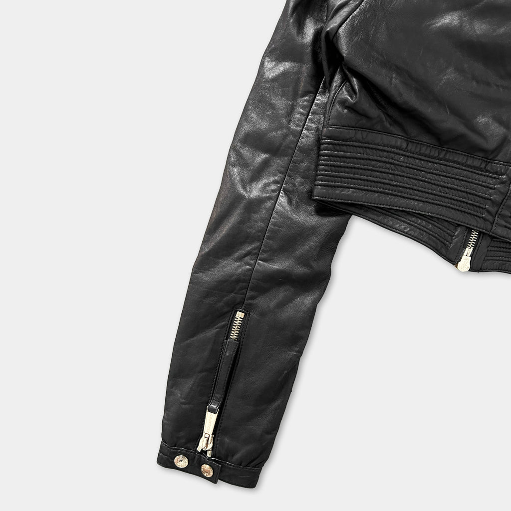 A close-up view of a black leather jacket with a zipper and buttons, showing the front and back of the jacket.