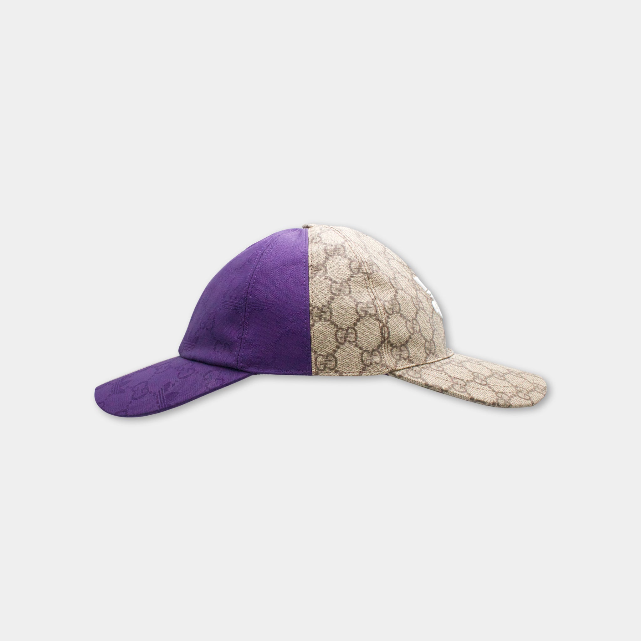 A purple and beige Gucci-patterned baseball cap is shown against a white background.