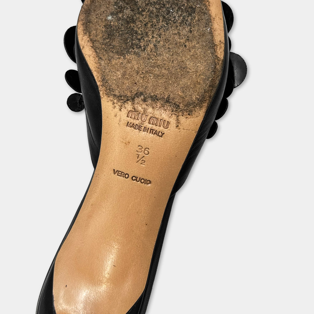 the sole of a high-heeled shoe, with dirt and grime visible on the surface.