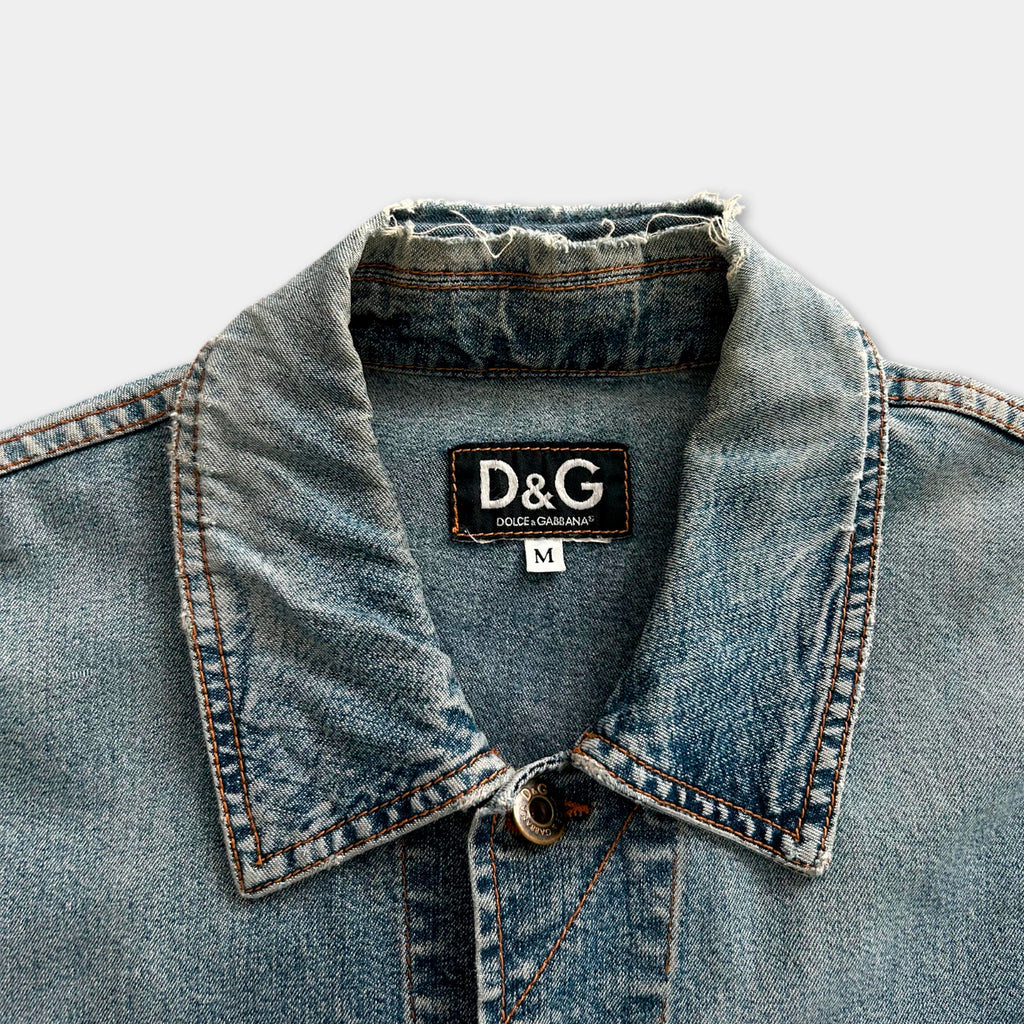 A close-up view of a denim jacket collar with a D&G (Dolce & Gabbana) label on the collar.