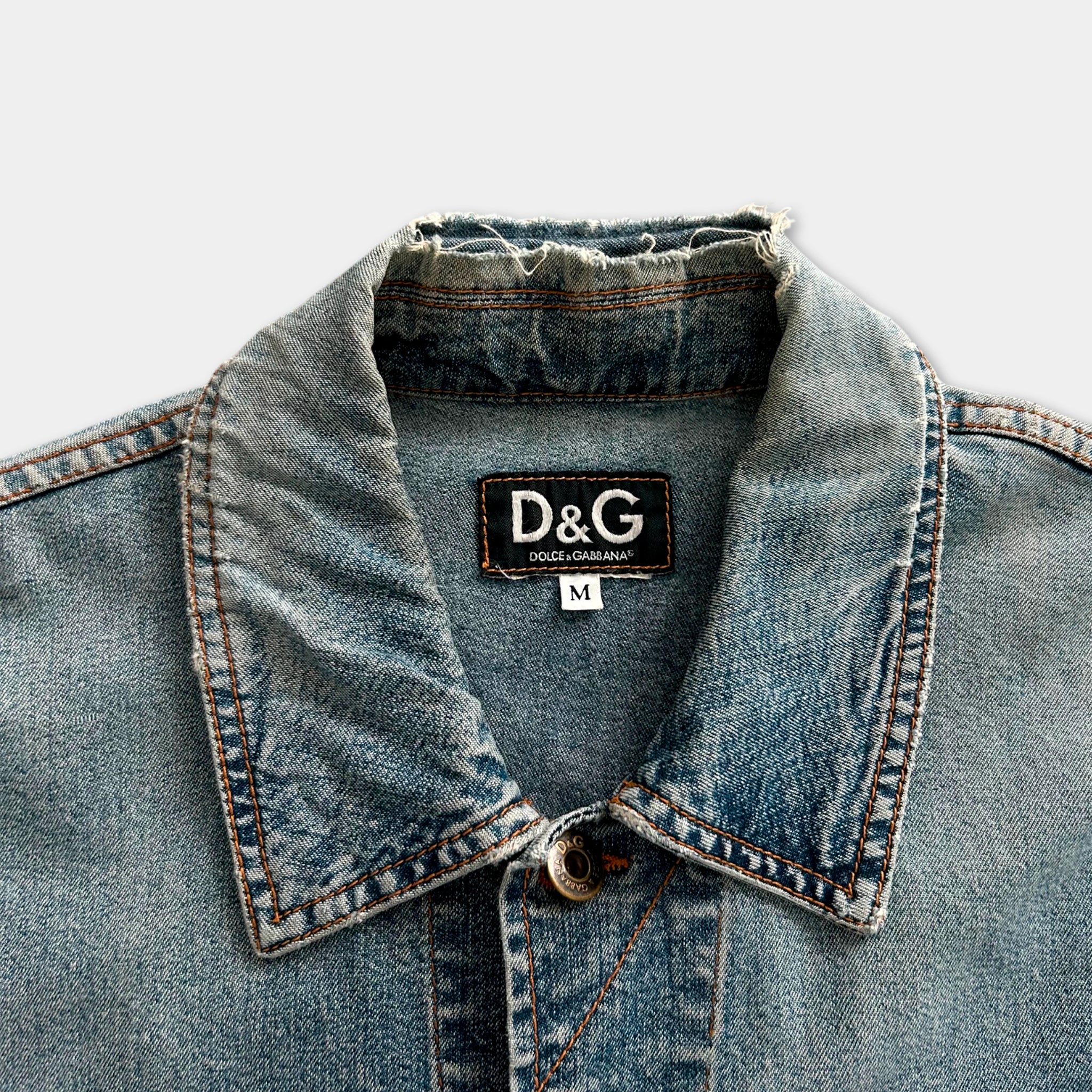 A close-up view of a denim jacket collar with a D&G (Dolce & Gabbana) label on the collar.