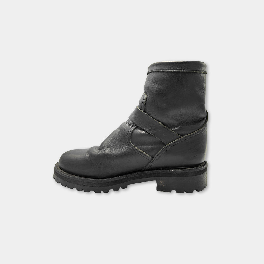 A single black leather boot against a white background.
