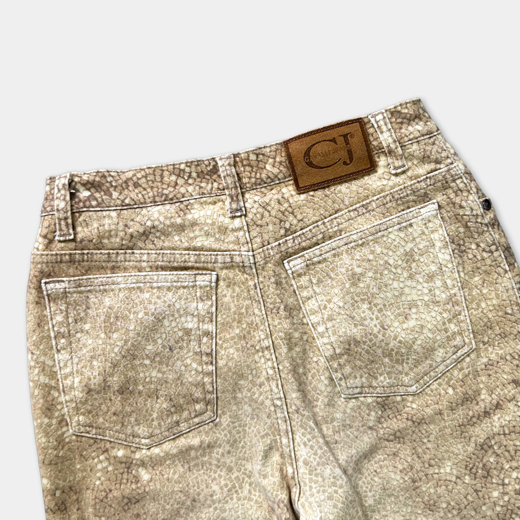 a pair of tan-colored jeans with a patterned design, featuring a small brown patch on the back pocket.