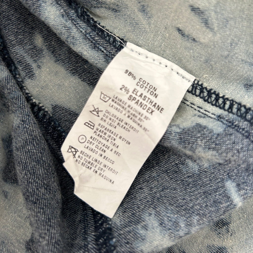 a close-up view of a fabric label with text and symbols, likely providing information about the fabric or care instructions for the clothing item.