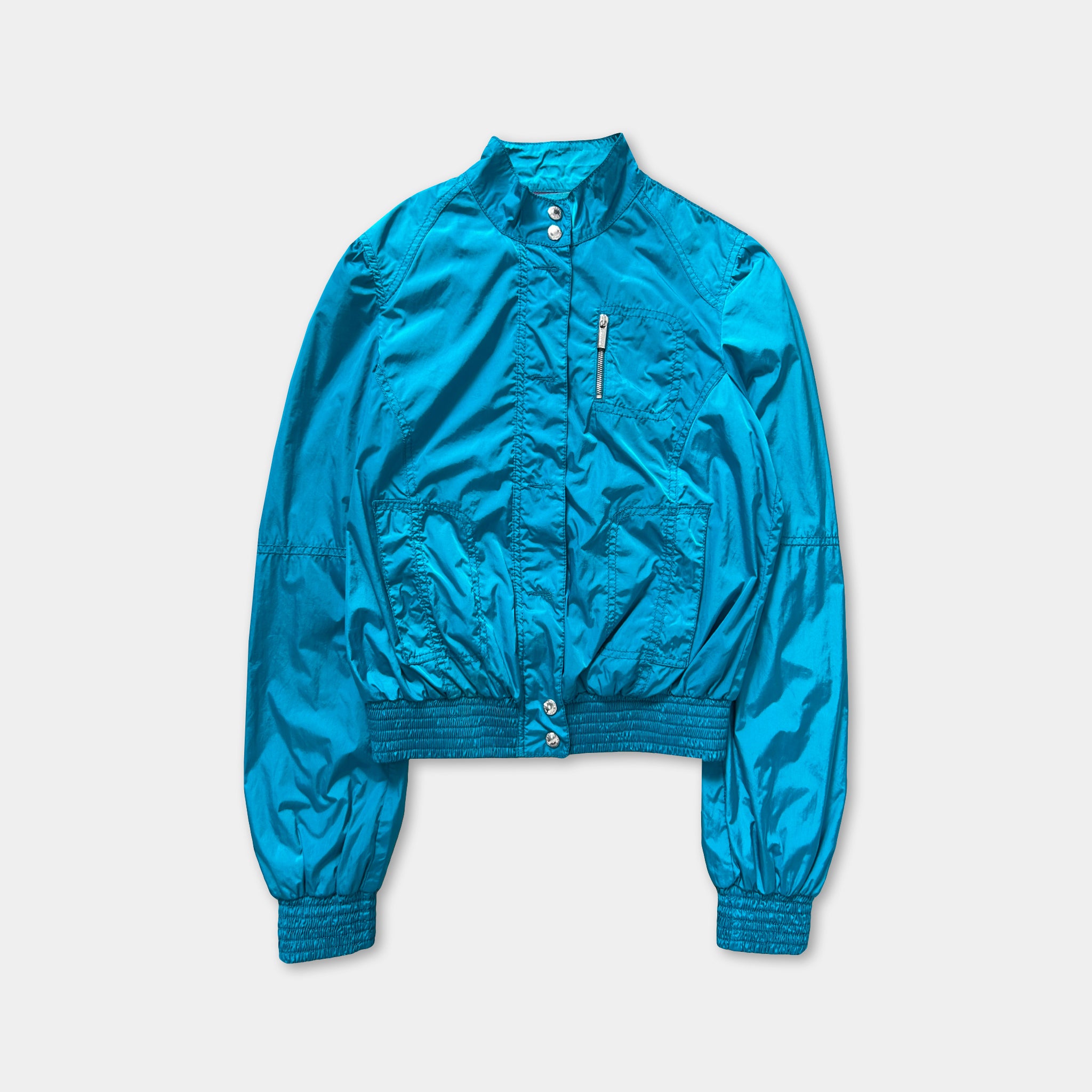 A turquoise-colored jacket with a zipper and pockets, displayed against a white background.