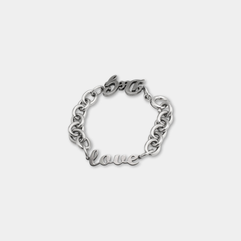 A silver-colored bracelet with the word "love" engraved on it.
