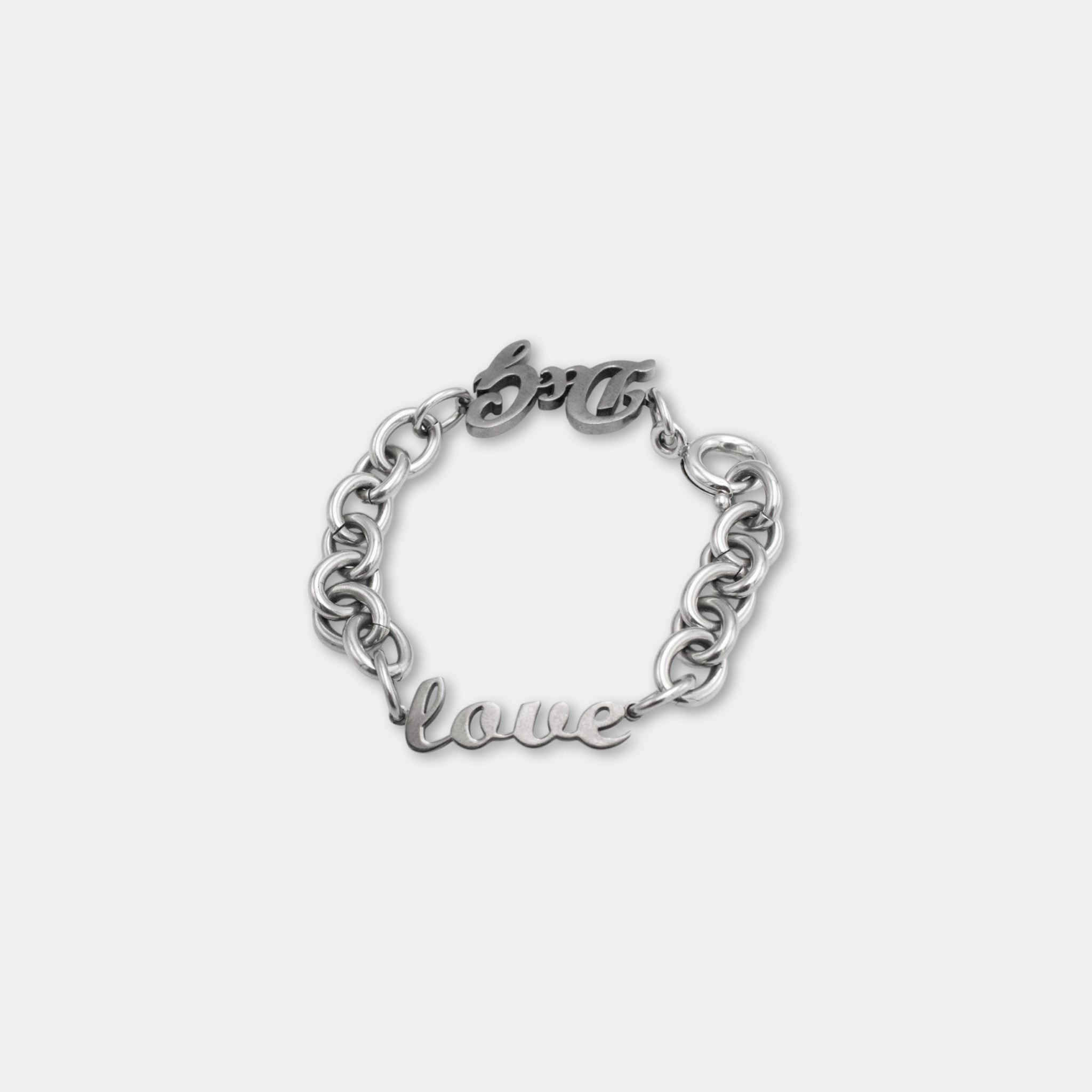 A silver-colored bracelet with the word "love" engraved on it.
