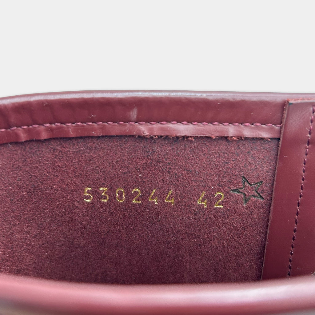 the inside of a red leather boot, with the number "5302444" and a star symbol printed on the leather.