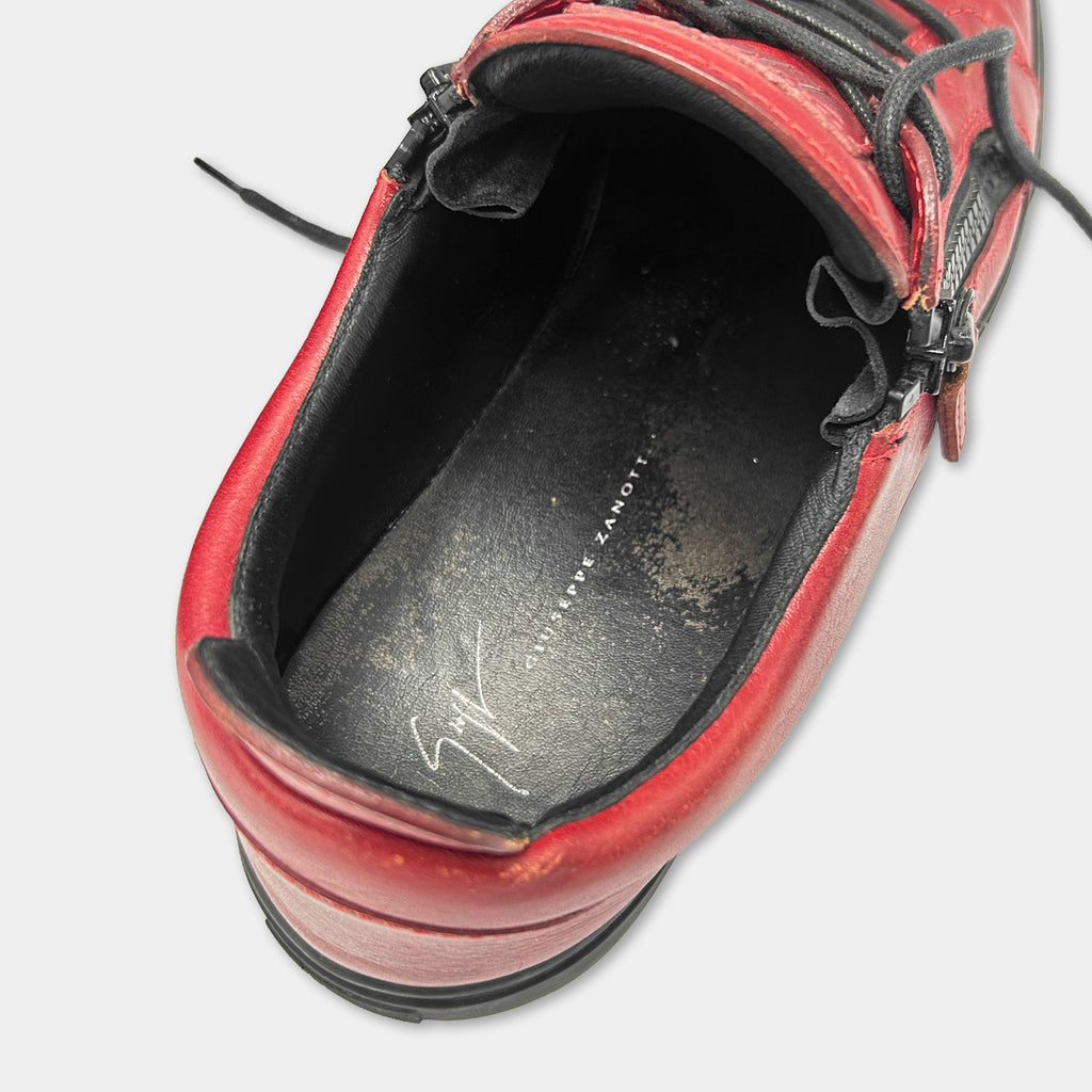 A close-up view of a red and black shoe, showing the sole and the upper part of the shoe.