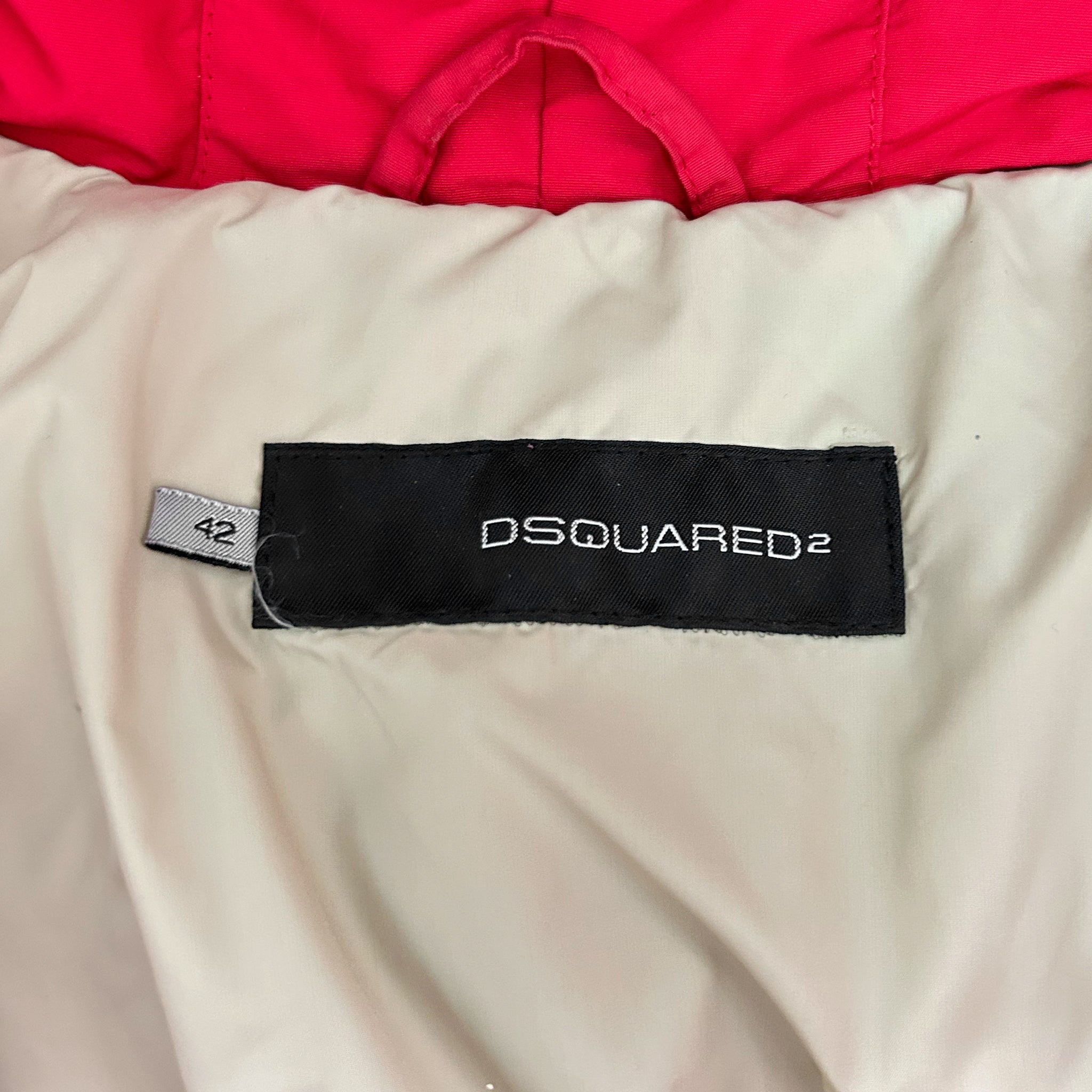 a close-up view of a red and white jacket with a black label on the back, displaying the brand name "DSQUARED".