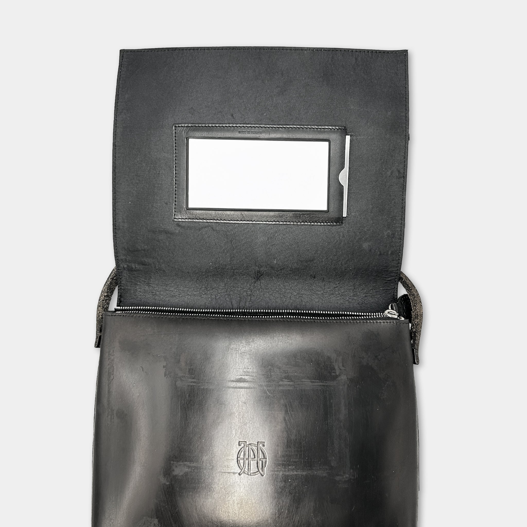 a black leather handbag with a white rectangular card slot on the front.