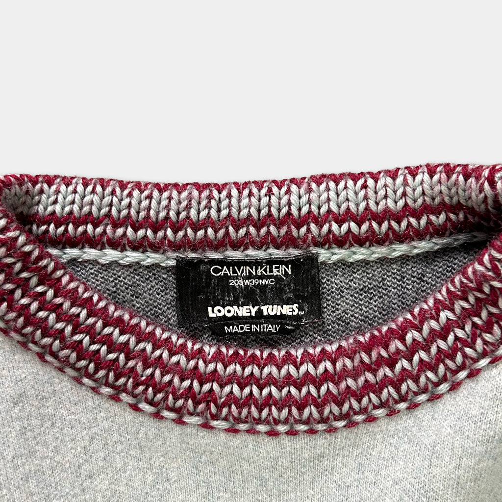 A close-up view of a knitted sweater collar with a label indicating the brand and product information.