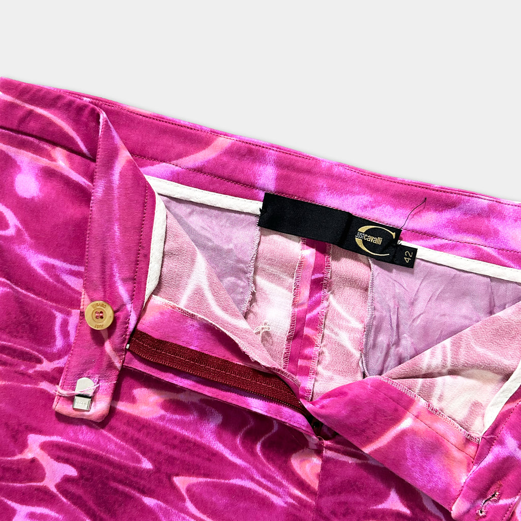 A close-up view of a pair of pink and white patterned pants with a black label attached to the waistband.