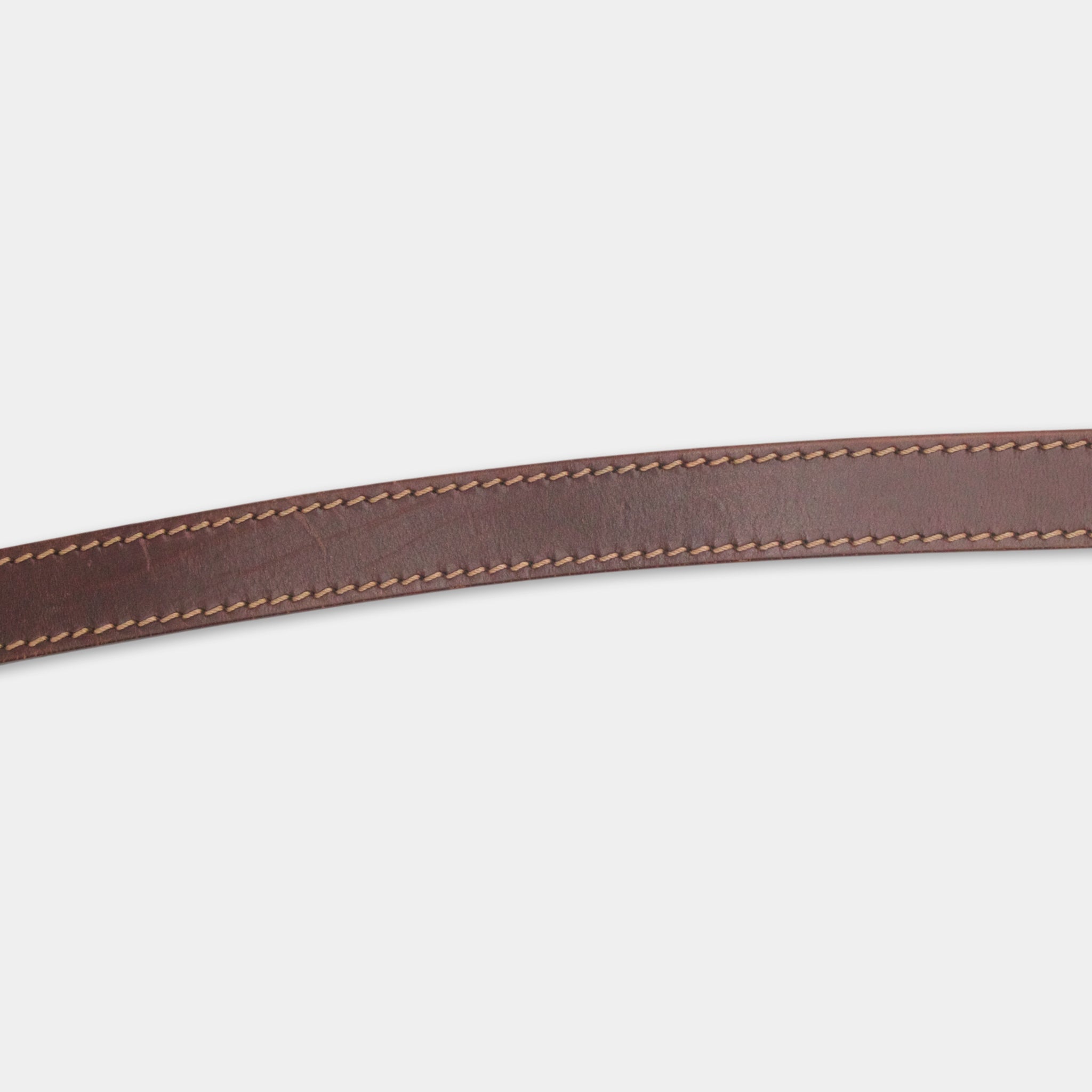 A close-up view of a brown leather belt with a simple stitching pattern.