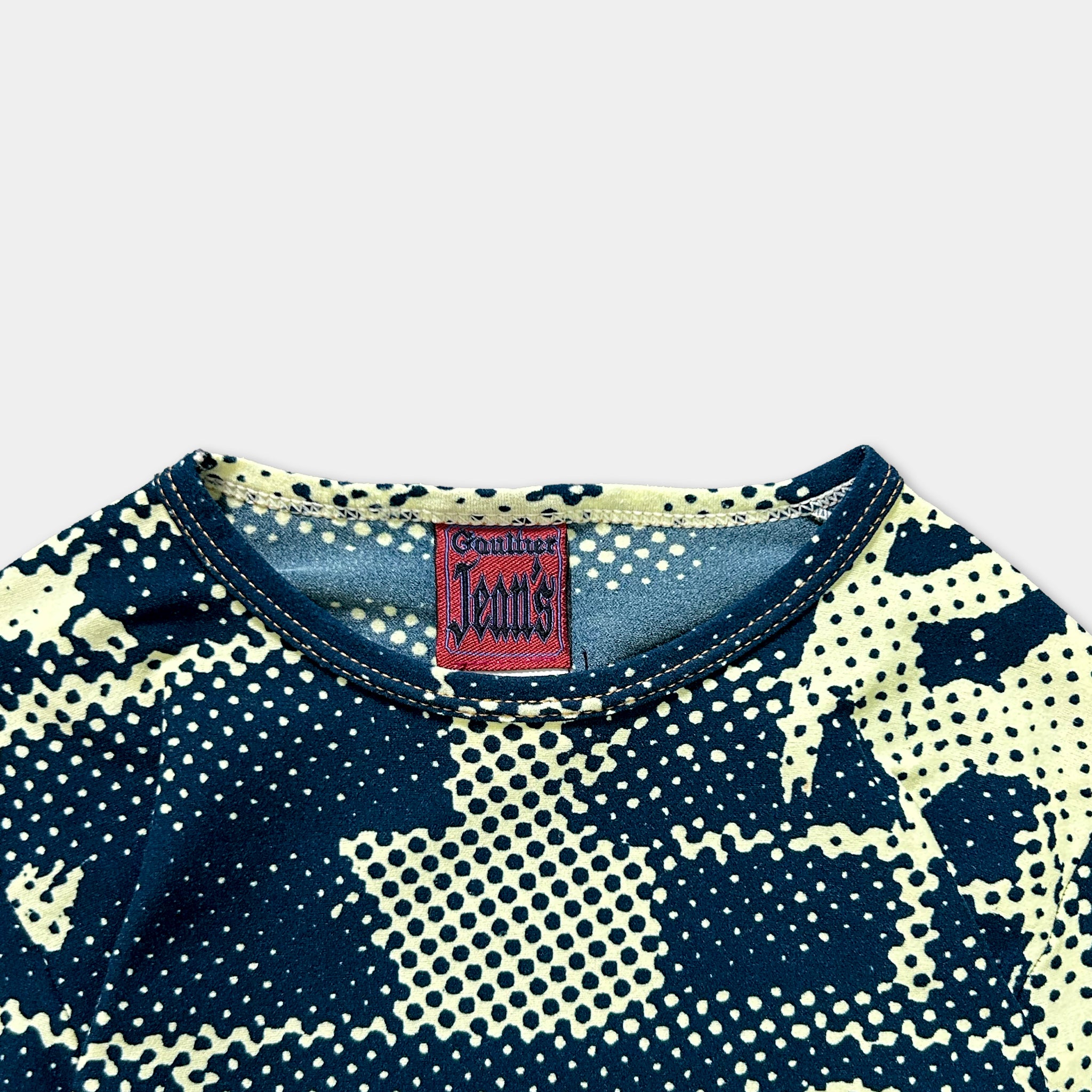 a close-up view of a patterned shirt with a collar and a red tag on the collar.