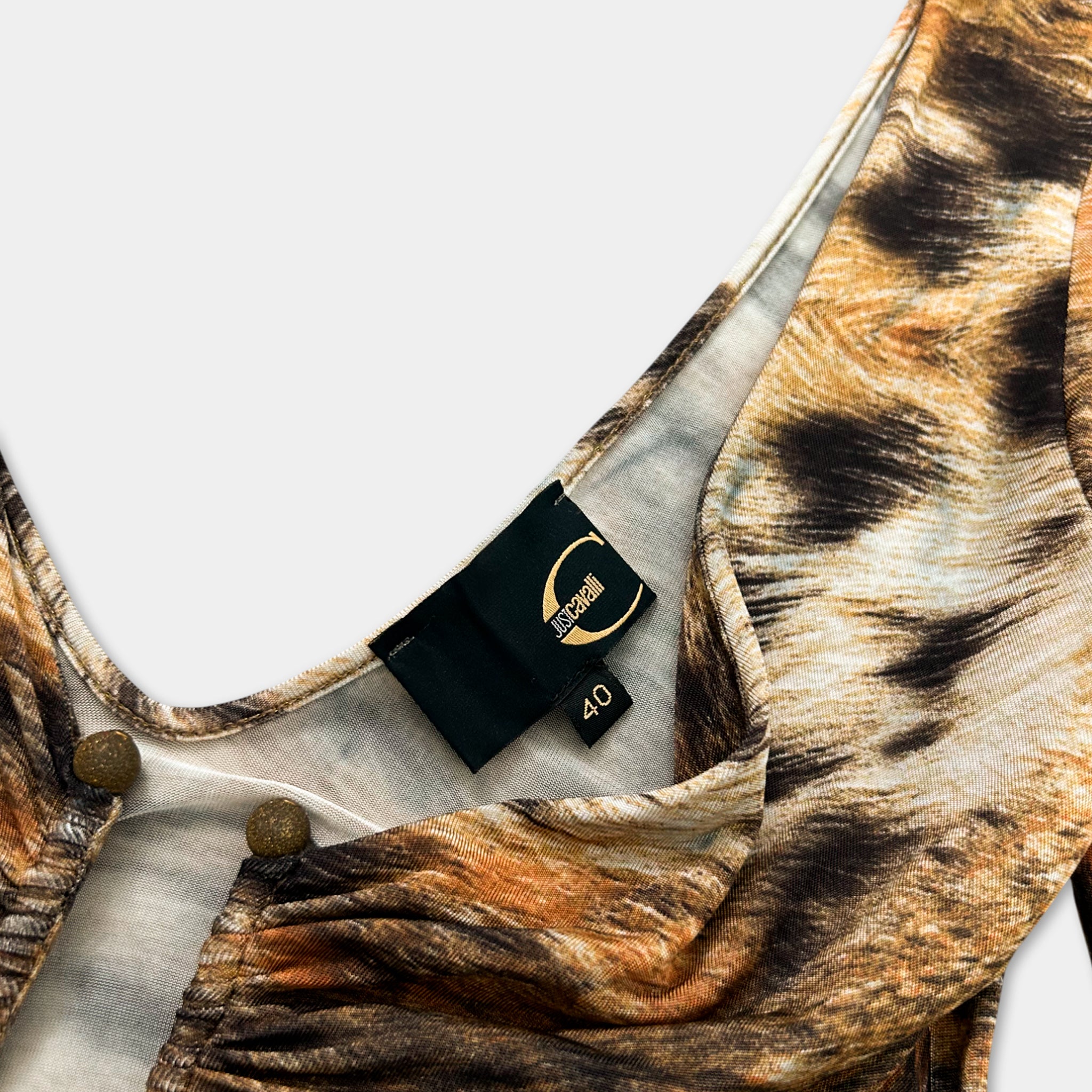 a close-up view of a patterned fabric, possibly a dress or blouse, with a label attached to it.