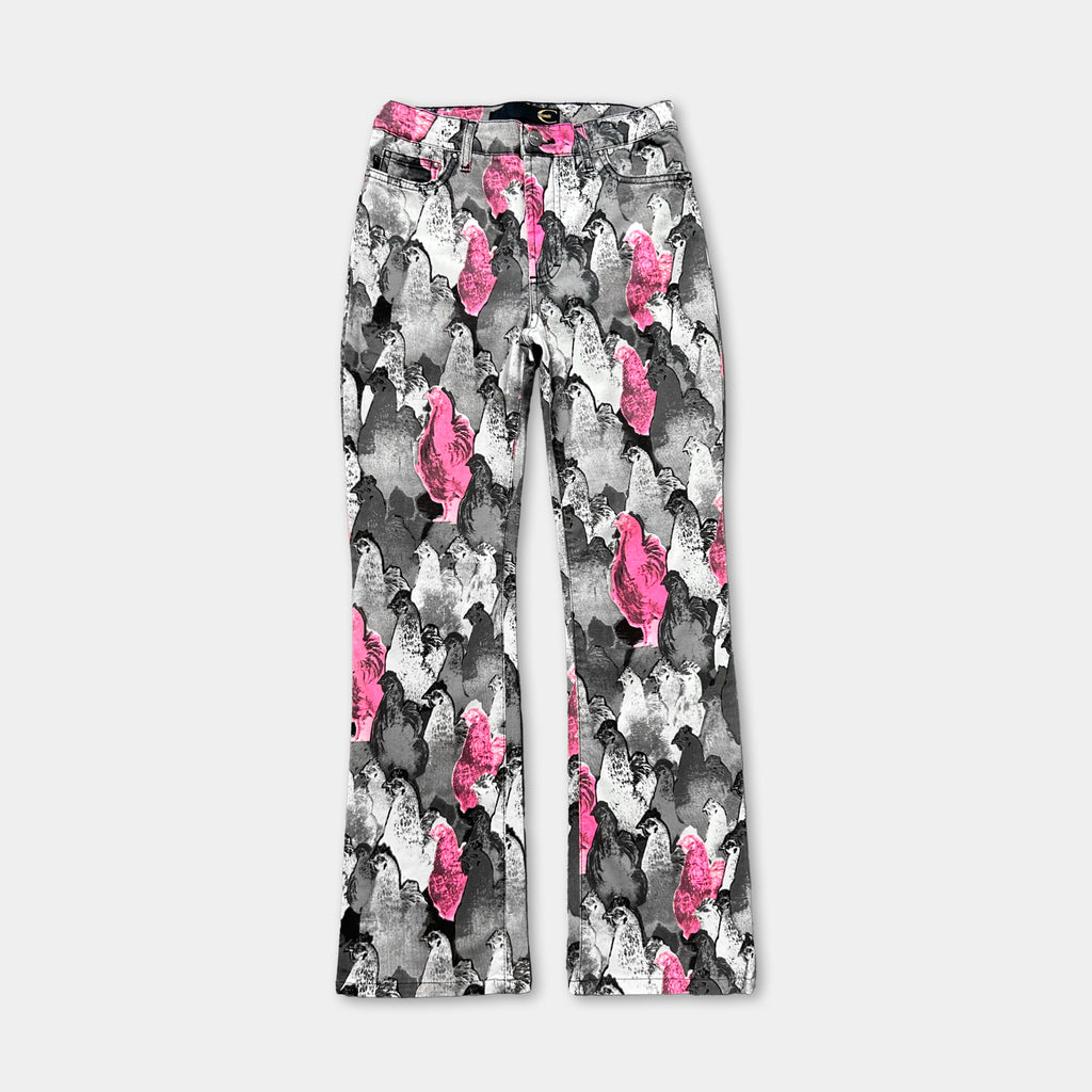 A pair of high-waisted jeans with a unique, colorful pattern of pink and black silhouettes.