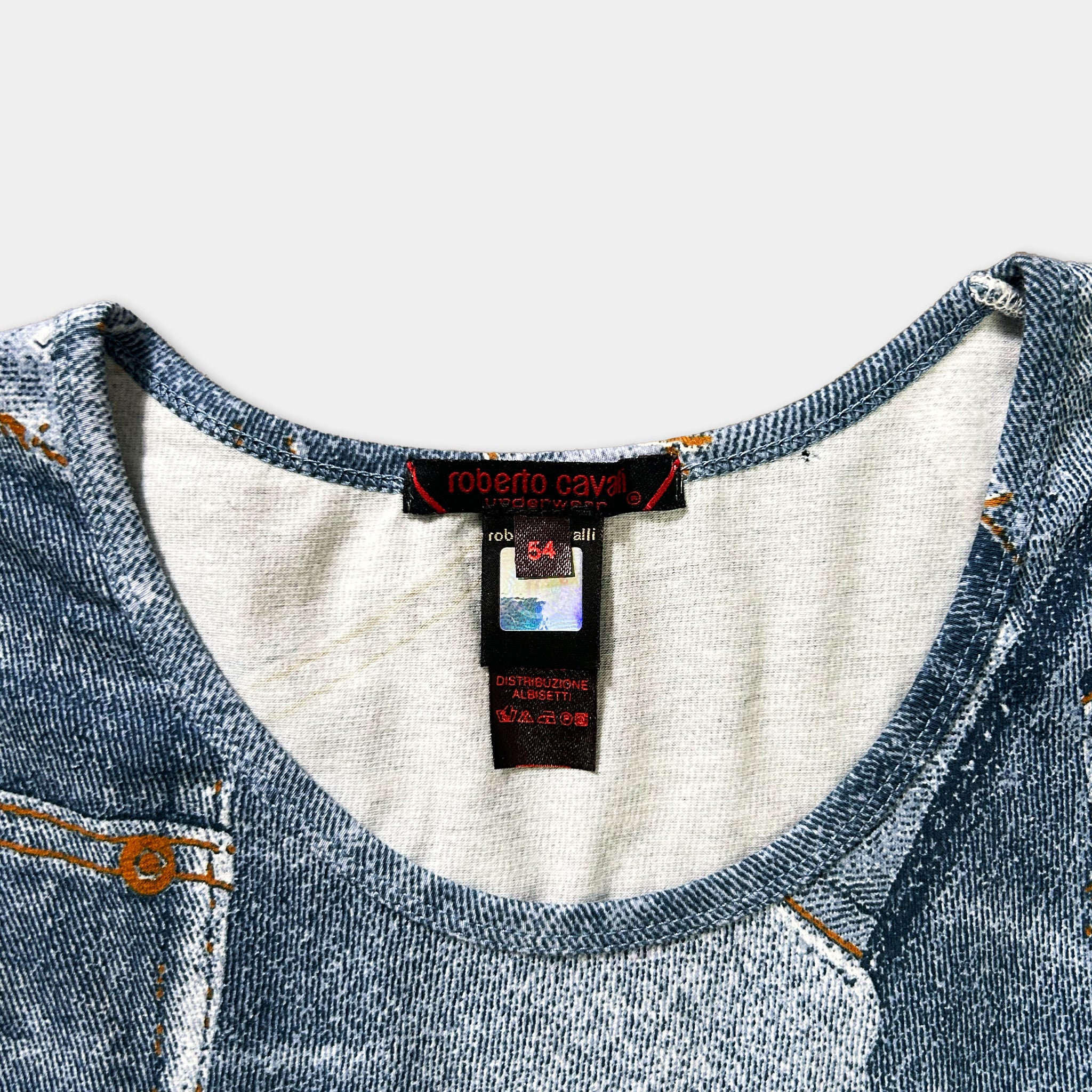 a close-up view of a blue denim-like fabric, possibly a shirt or blouse, with a label attached to it.
