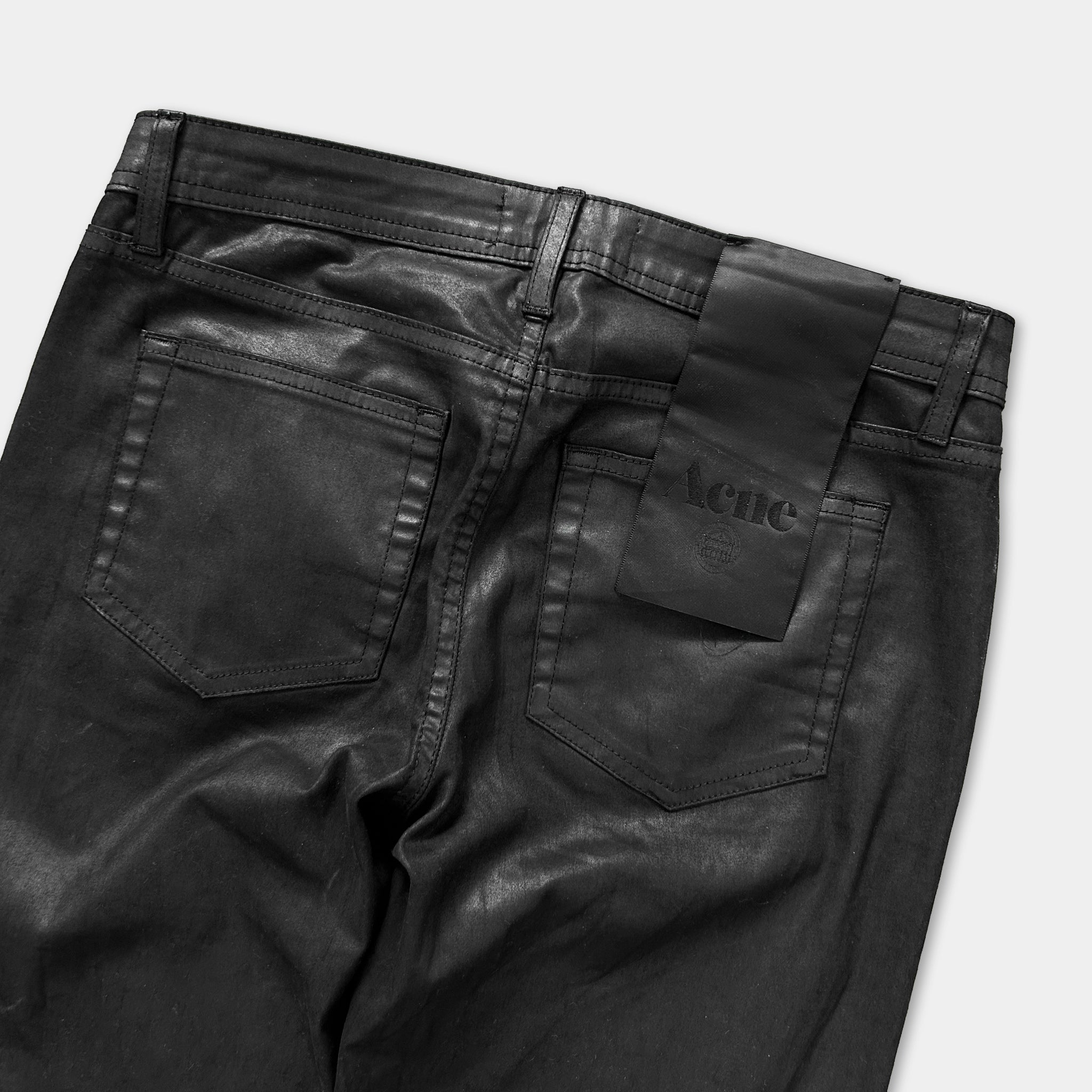 a pair of black leather jeans with a tag attached to the waistband.
