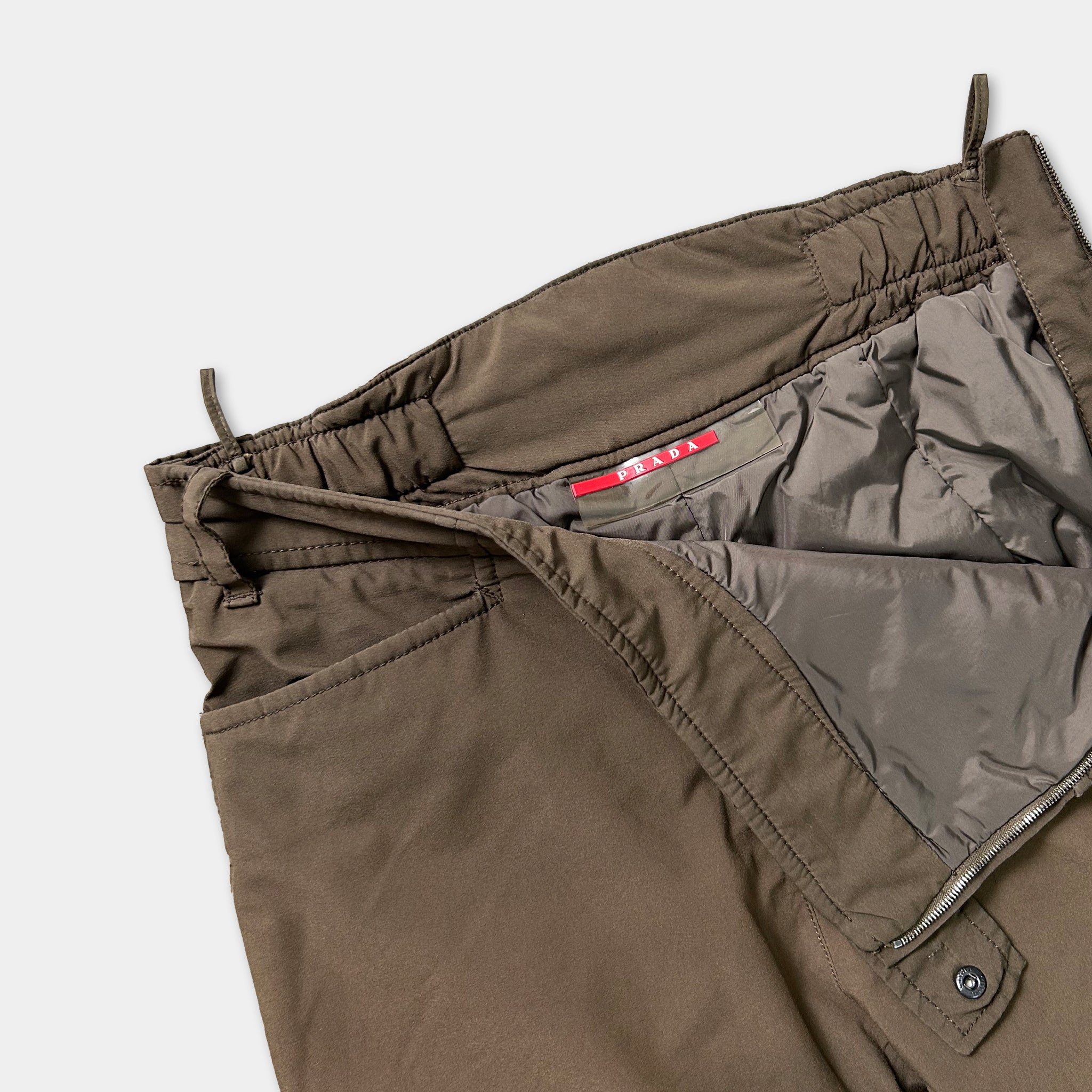 A pair of brown pants with a red label on the waistband.