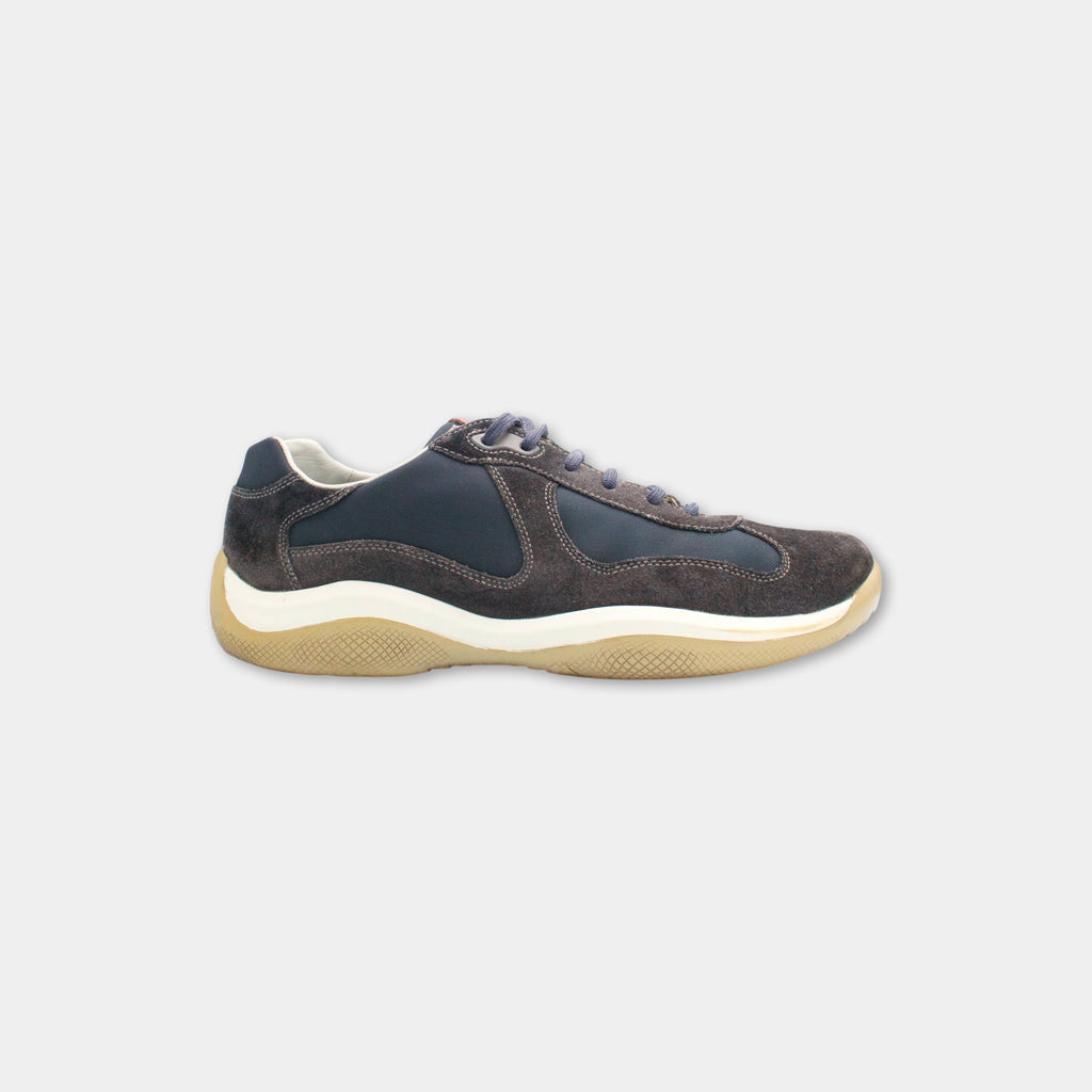 A dark blue and tan athletic shoe with a white sole.