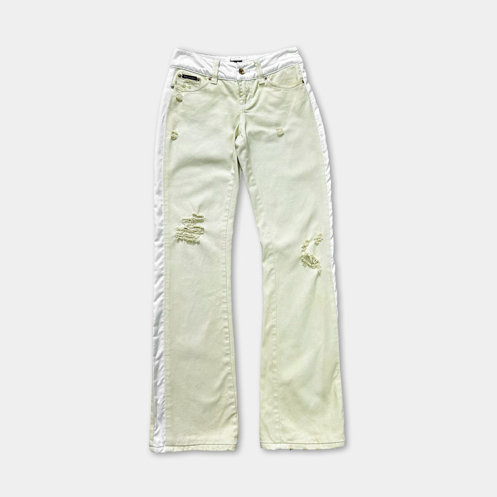 A pair of white jeans with visible tears and holes in the fabric.