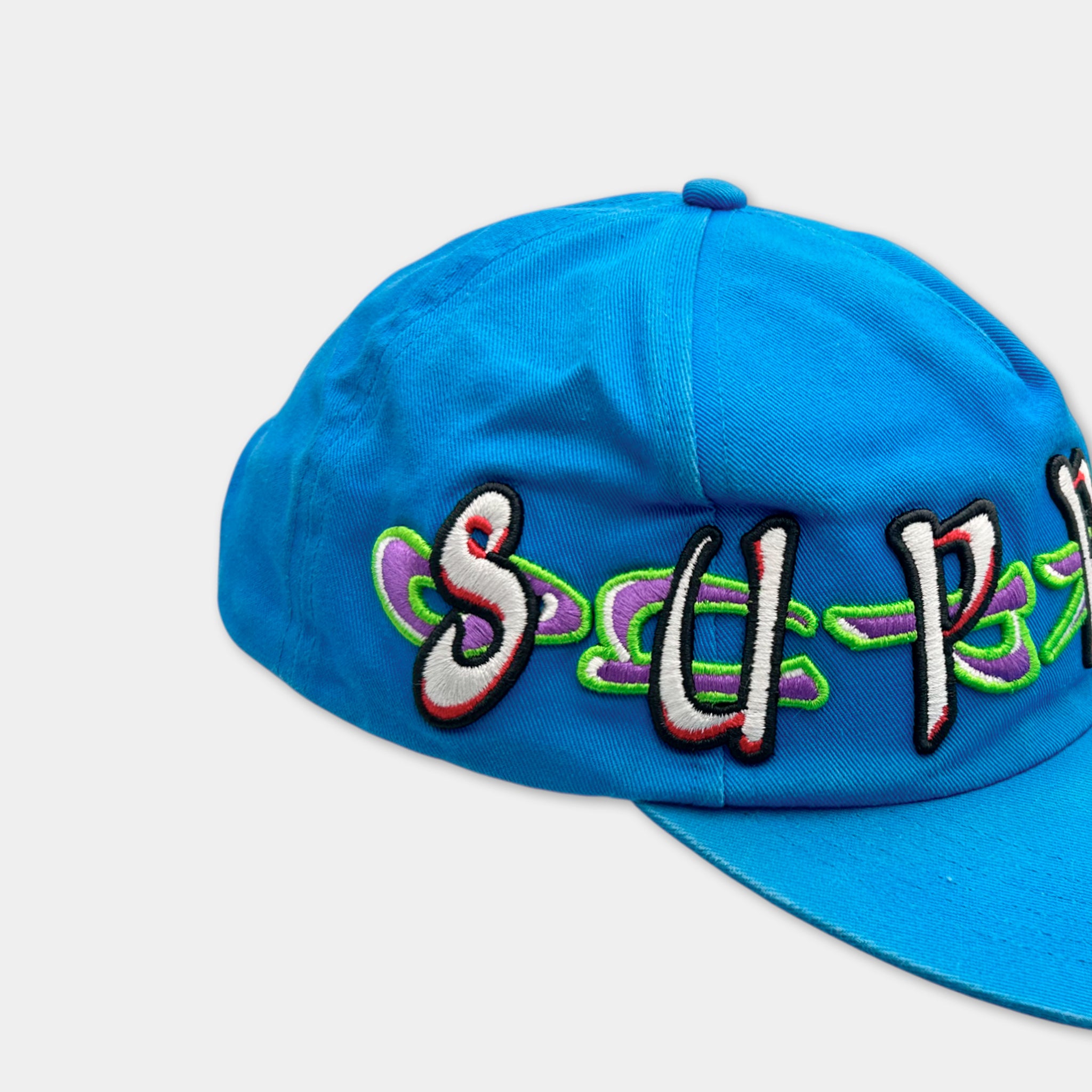A blue baseball cap with colorful embroidered text on it.