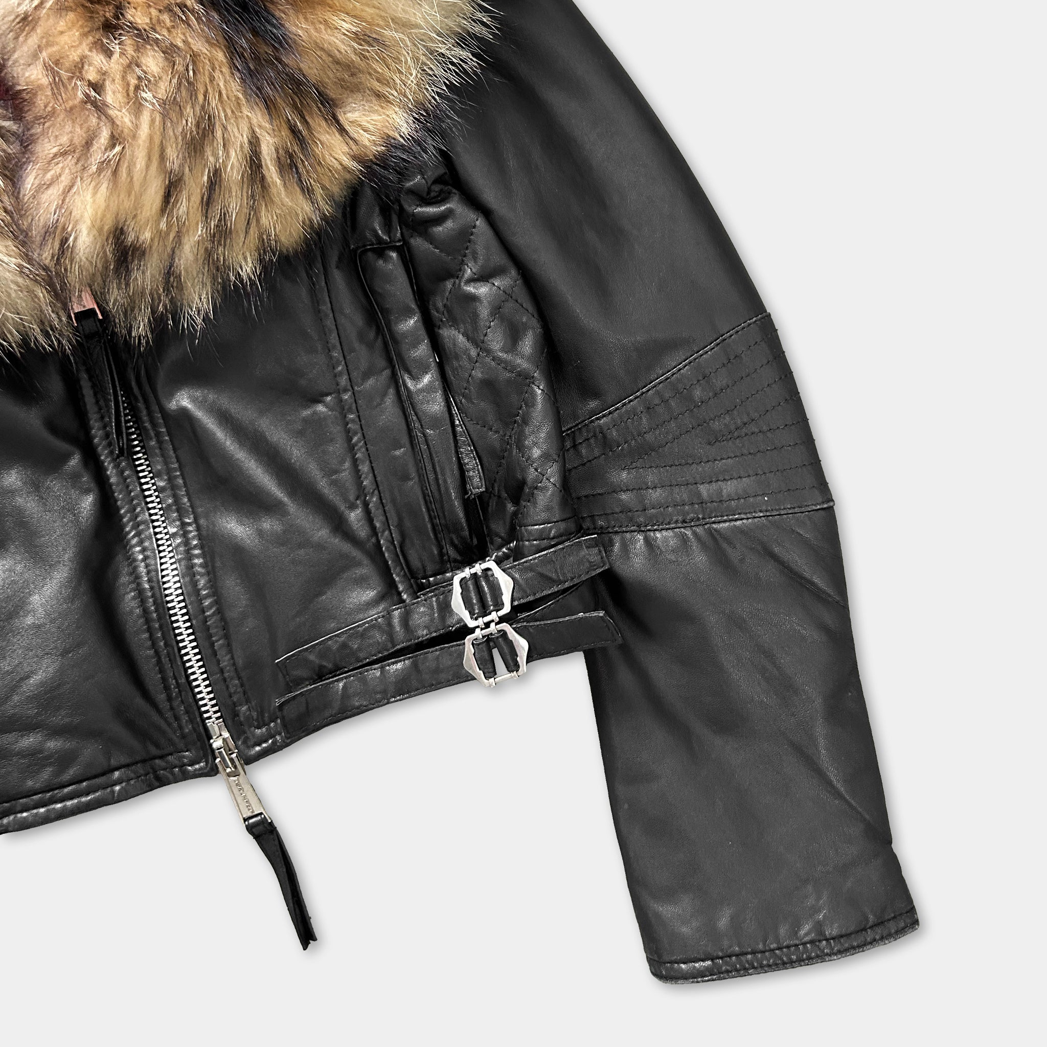 A close-up view of a black leather jacket with a fur collar.