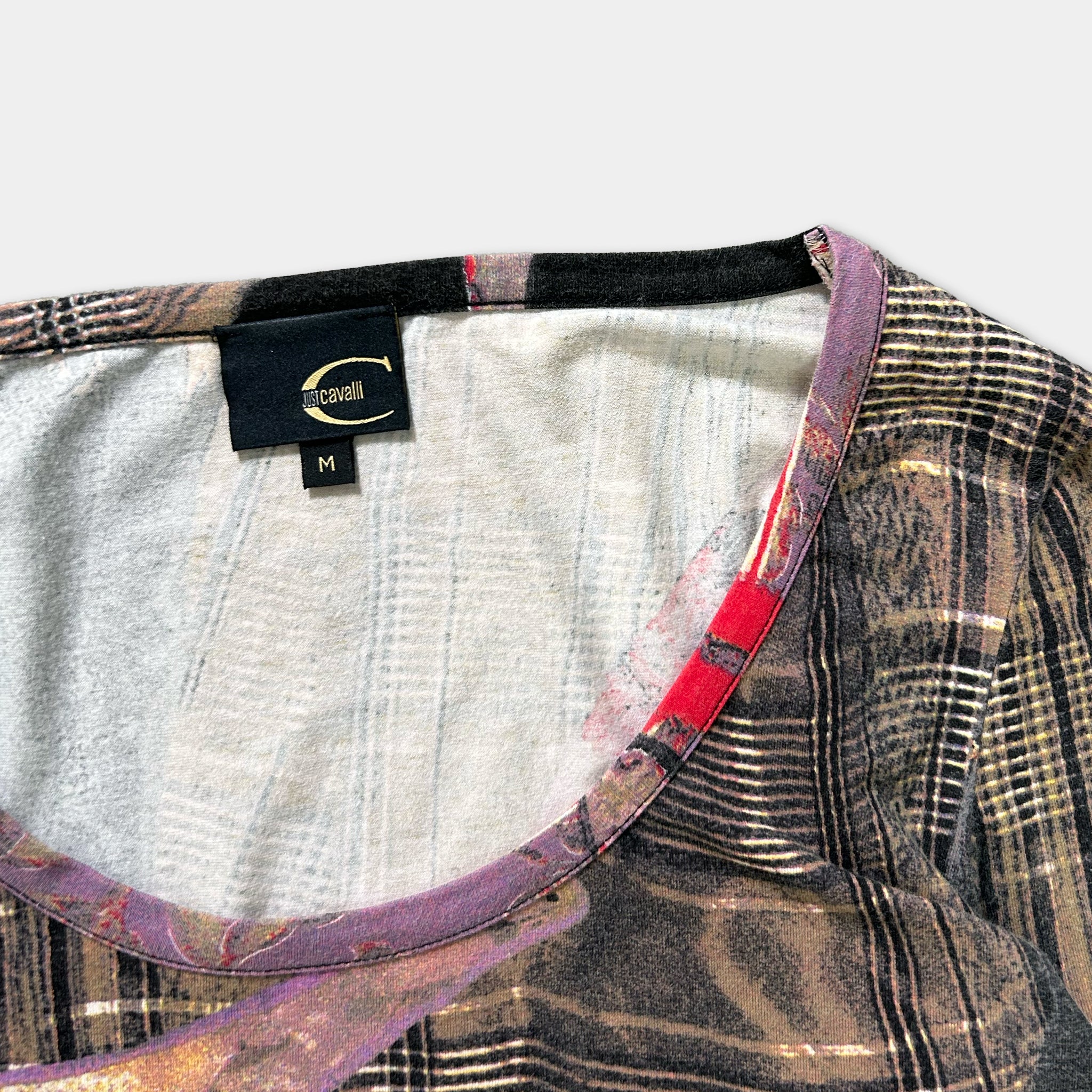 a close-up view of a patterned shirt collar, with a label indicating the brand and size.