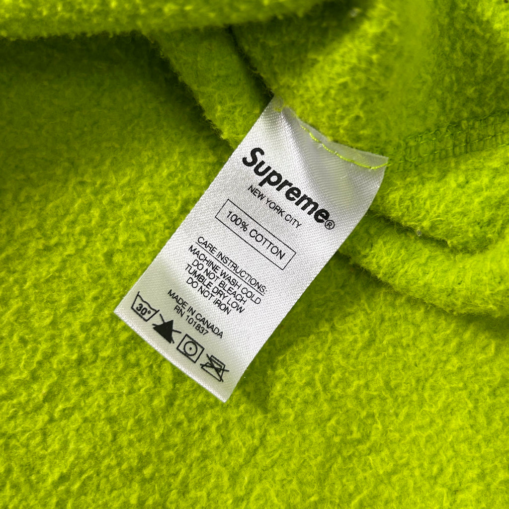 A white label with black text is attached to a bright green fabric.