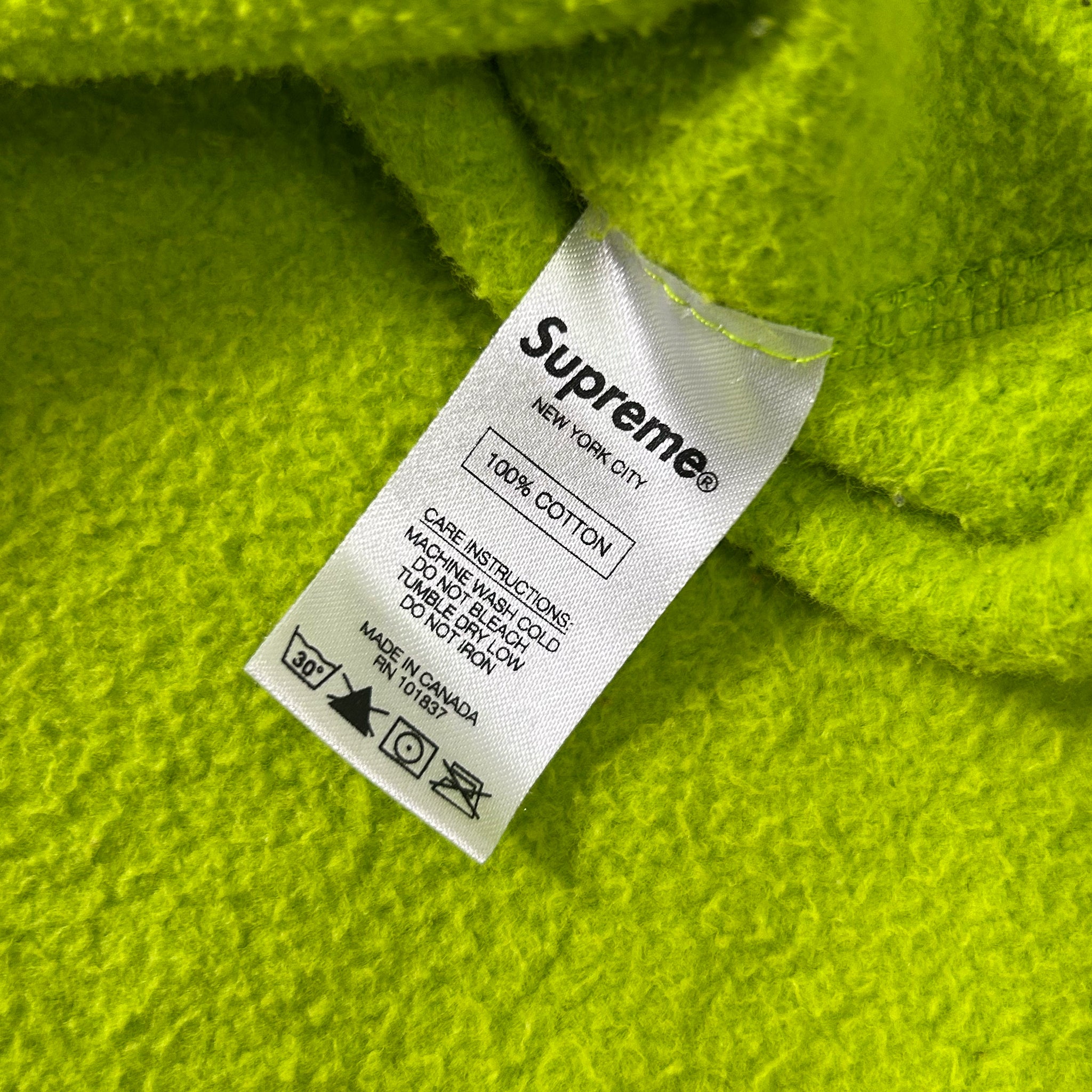 A white label with black text is attached to a bright green fabric.