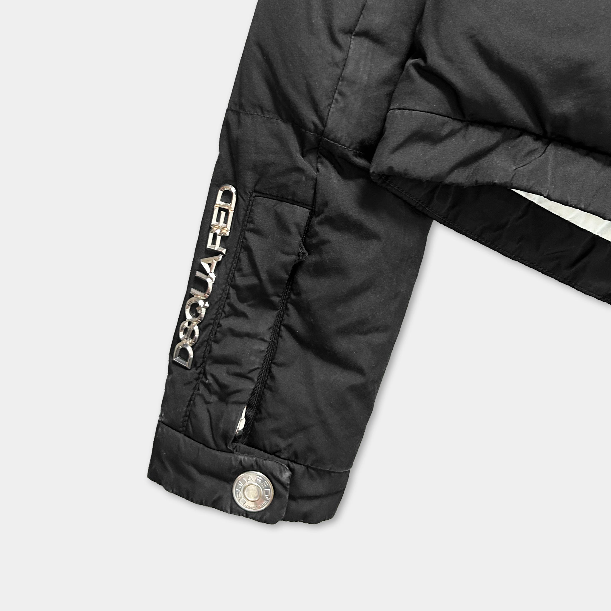 A close-up view of a black jacket with the brand name "DISQUA FED" printed on the sleeve.