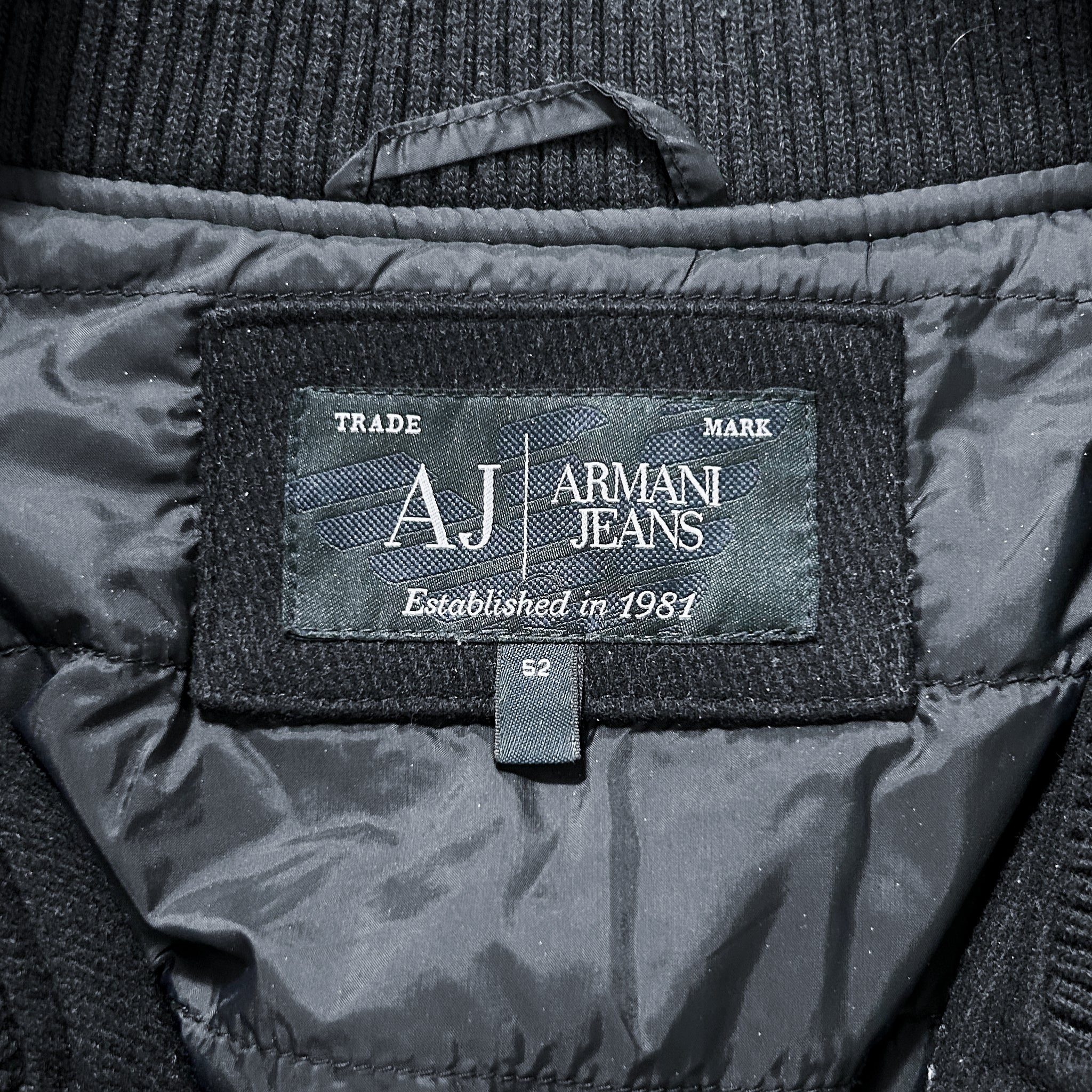 a close-up view of a black jacket with a label that displays the brand name and establishment year.