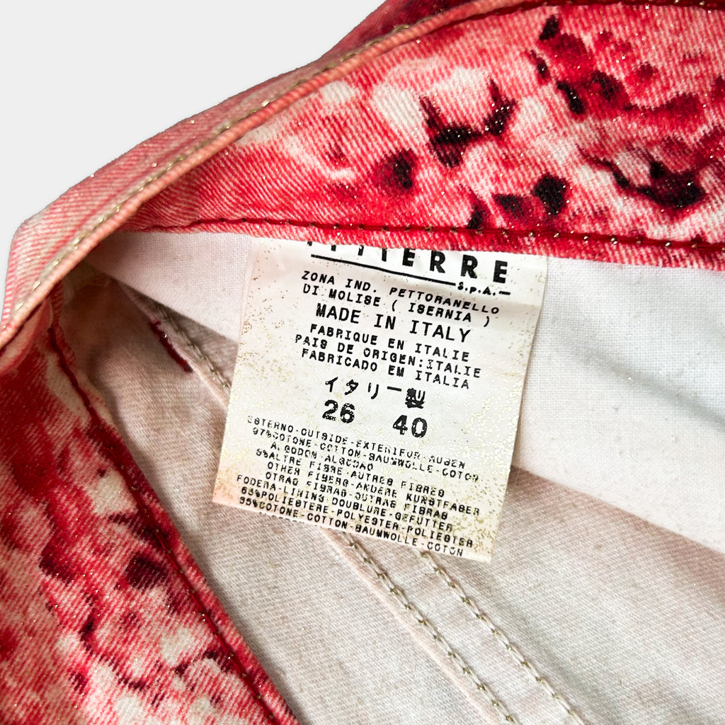 a close-up view of a label on a pair of red and white patterned pants, providing information about the pants' origin and material.