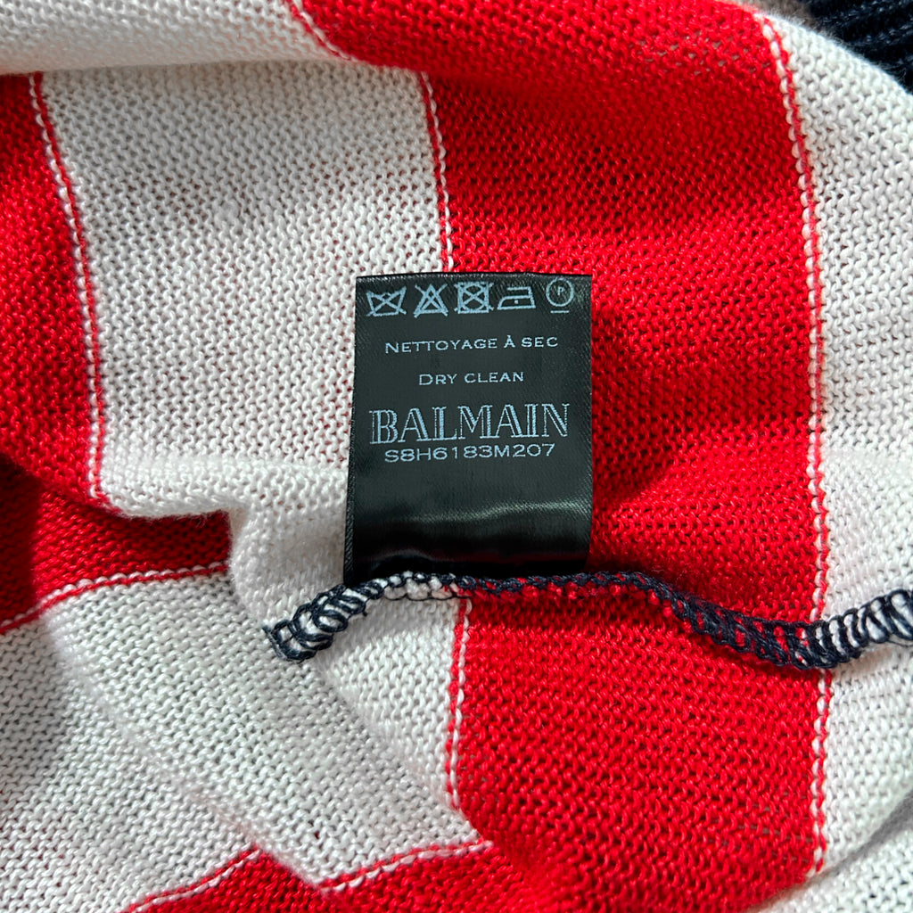 A close-up image of a black label with white text on a red and white striped fabric.