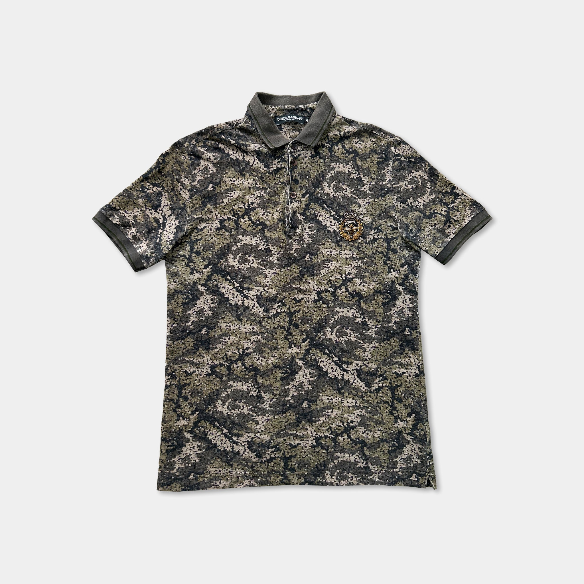 a camouflage-patterned polo shirt with a collar and short sleeves, displayed against a plain background.