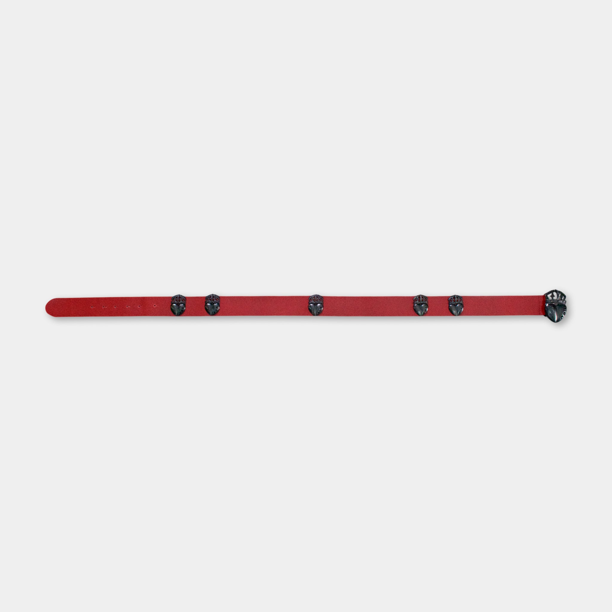 A red belt with black circular embellishments is shown against a plain white background.