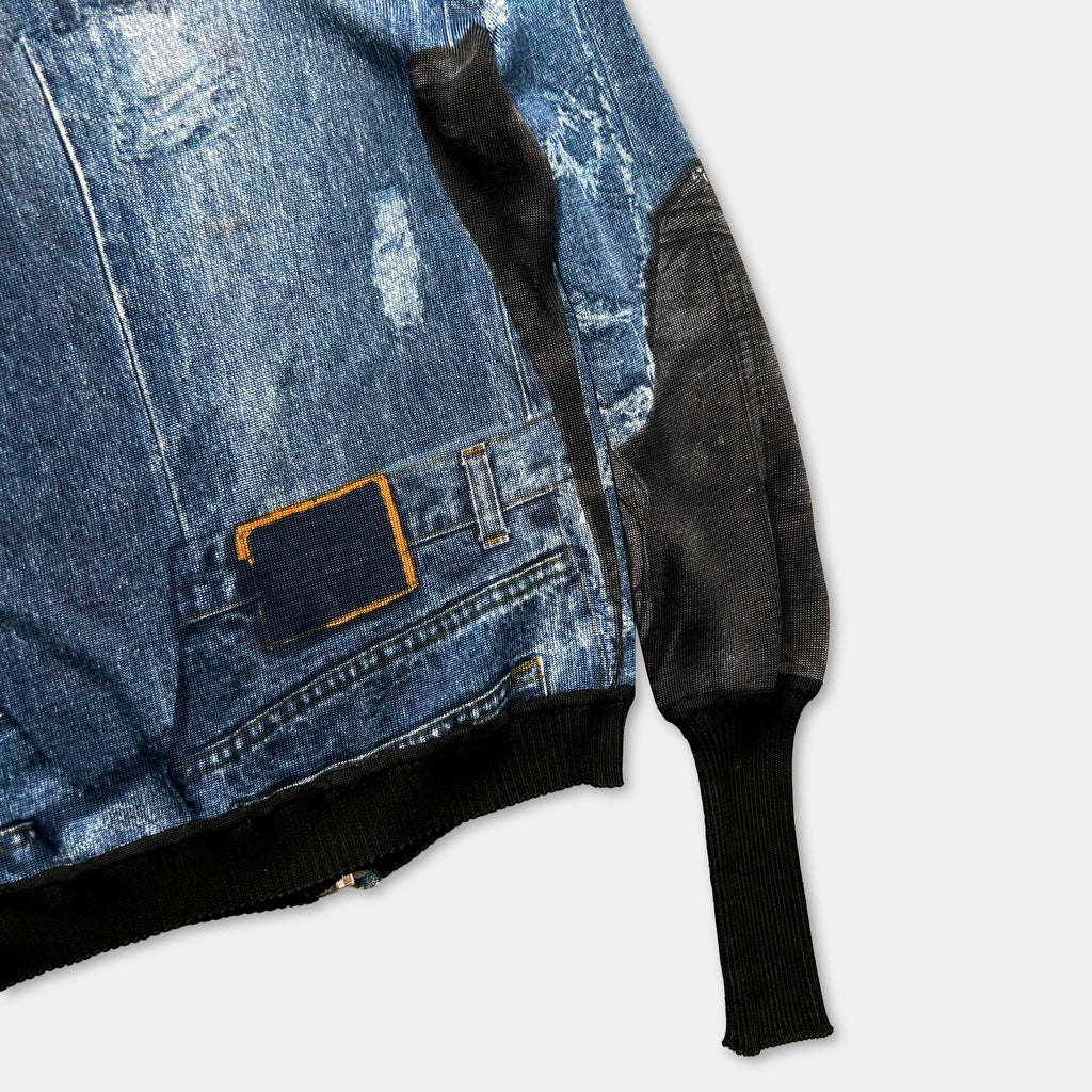 a close-up view of a denim jacket with a black sleeve and a small patch of fabric attached to the sleeve.