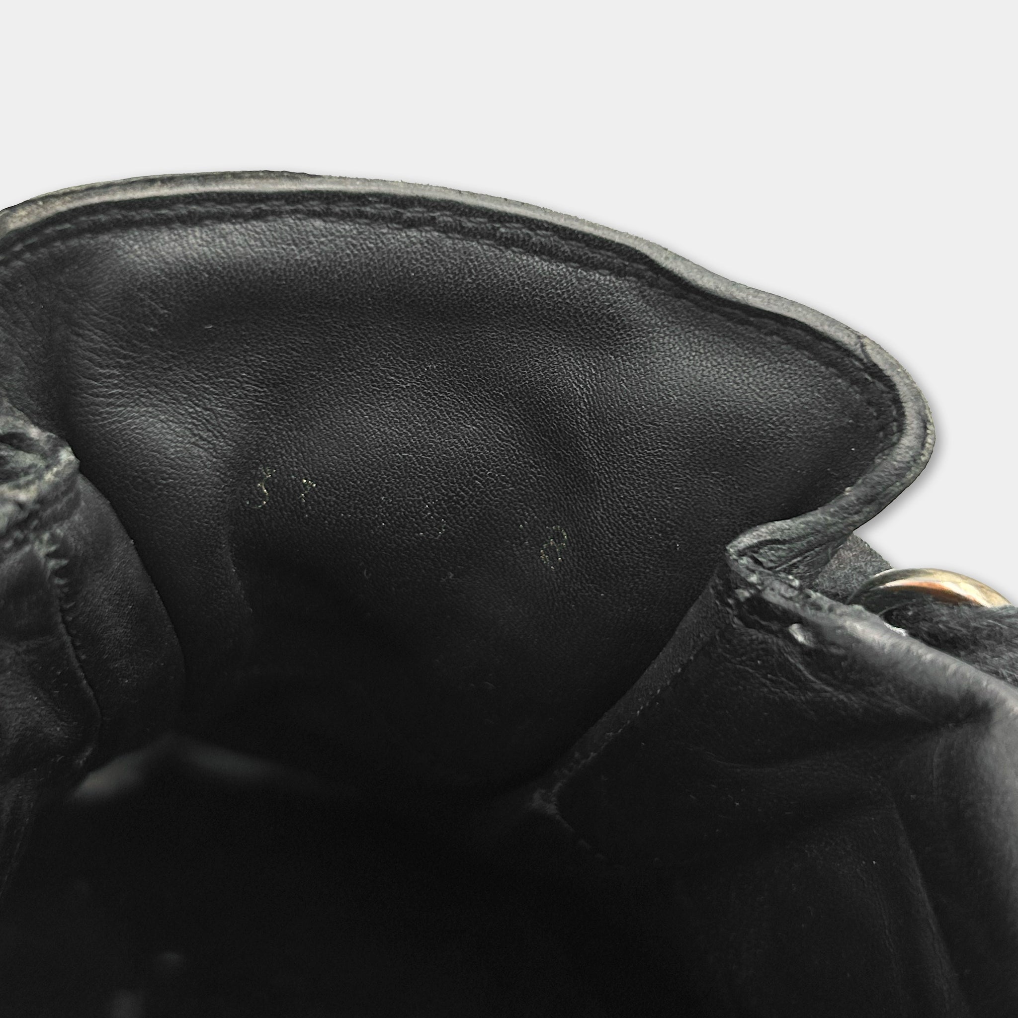 the interior of a black leather shoe, specifically the sole and the interior of the shoe.
