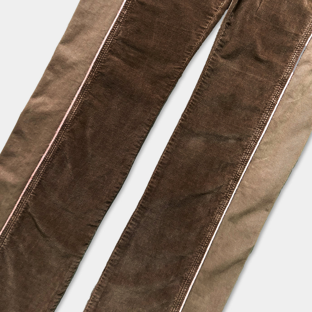 A close-up view of a pair of brown jeans with a white stripe running down the side.