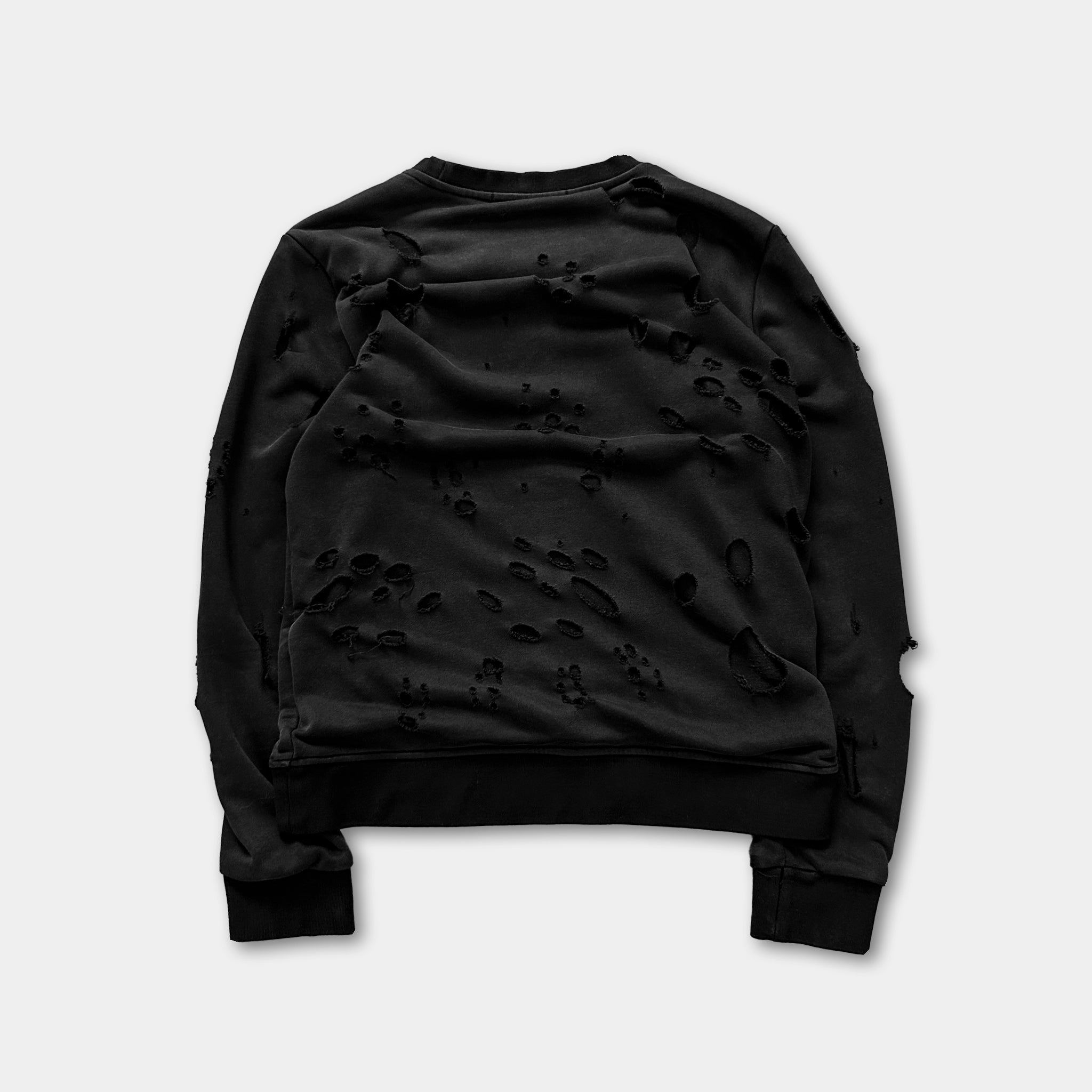 a black sweater with holes and tears in the fabric.