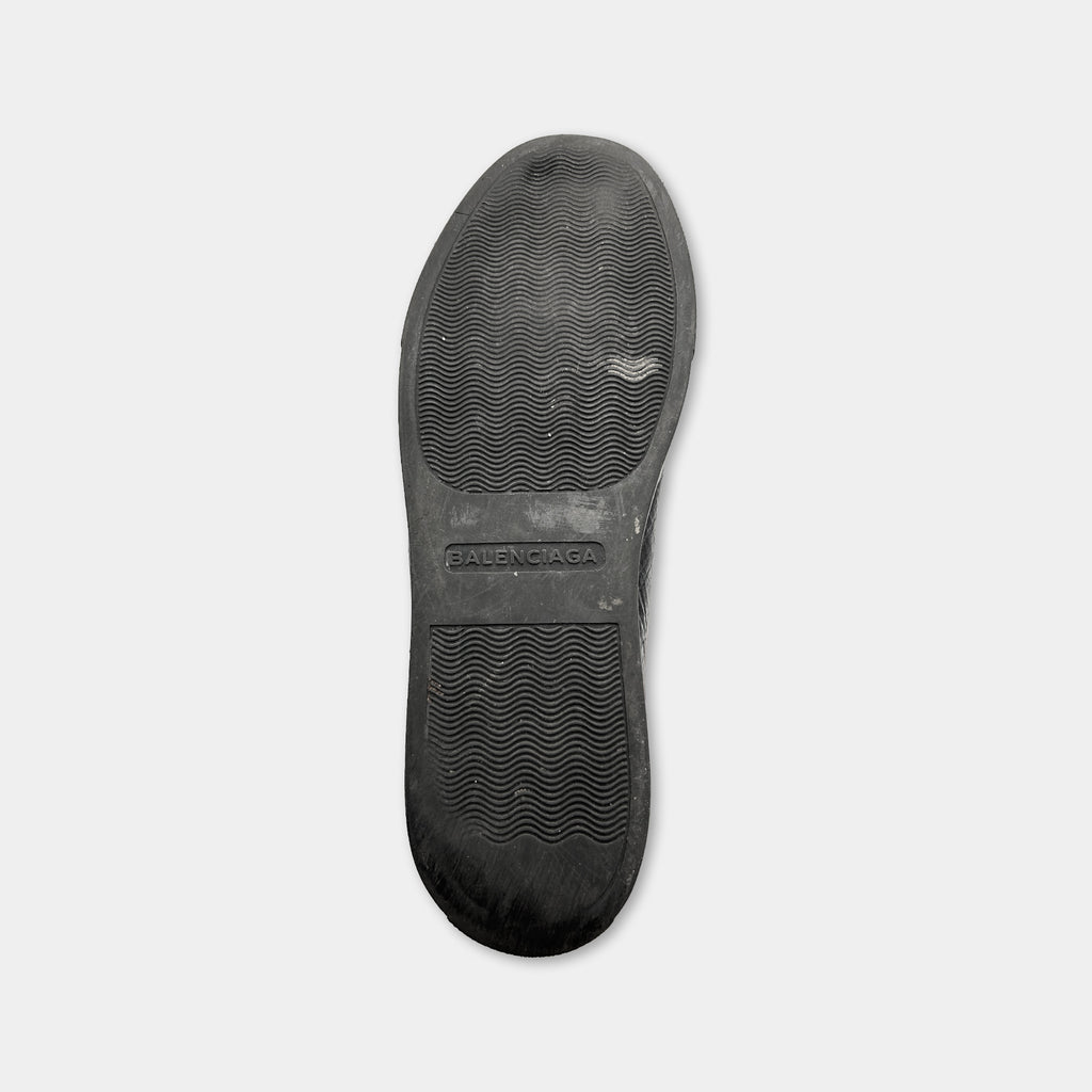 A black rubber sole of a shoe, with the brand name "ALENCAGA" printed on it.