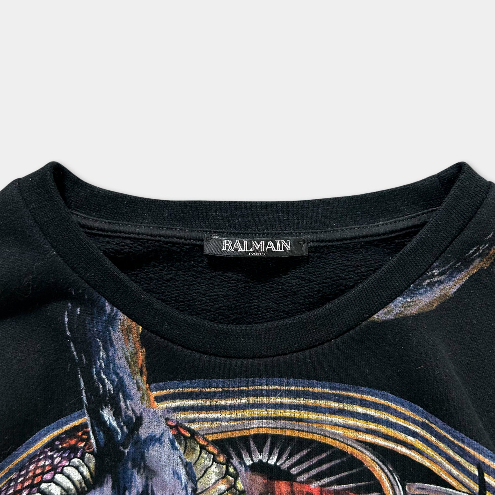 A close-up view of a black t-shirt with a printed design featuring a colorful, abstract pattern.