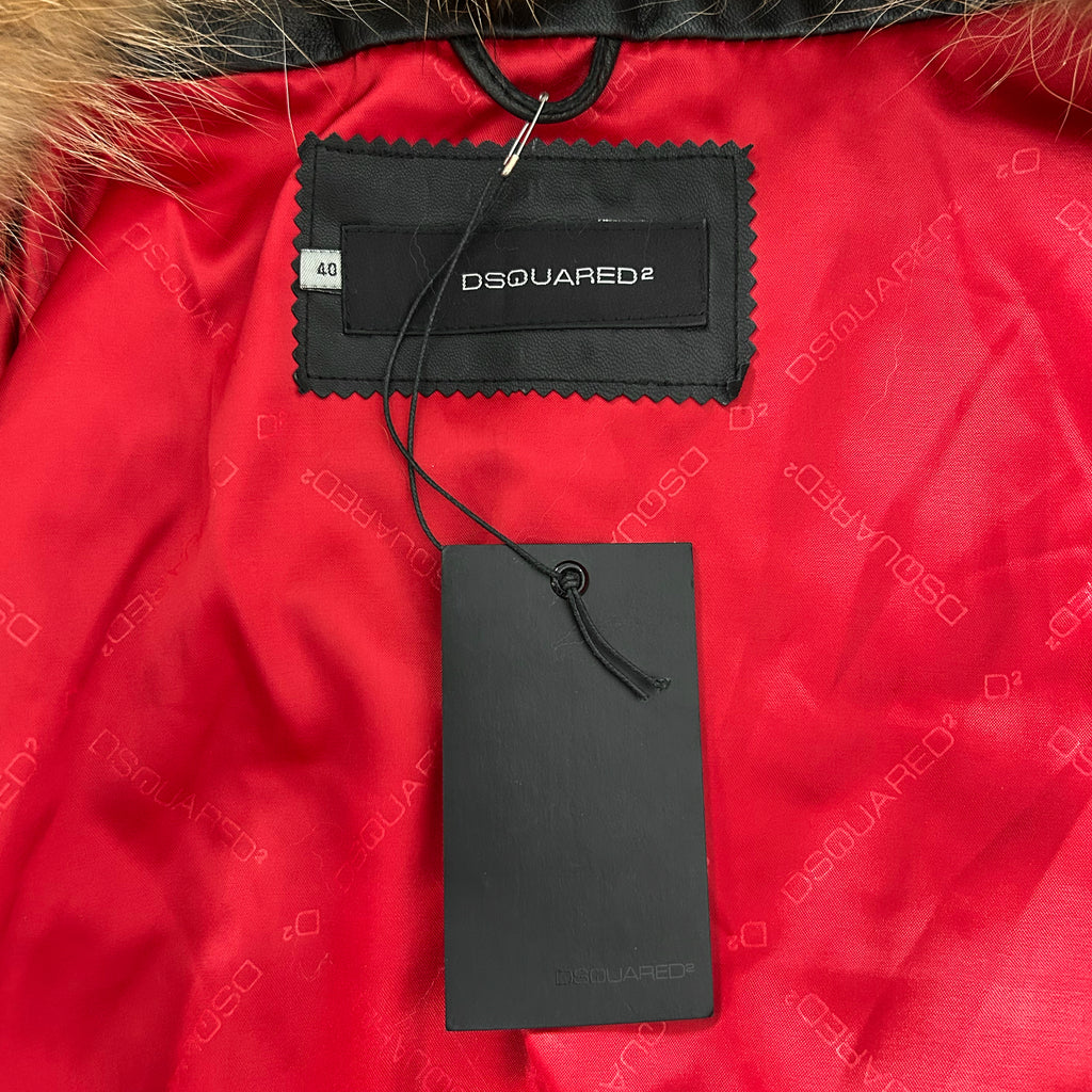 a close-up view of a red fabric with a black tag attached to it, displaying the brand name "DSQUARED".