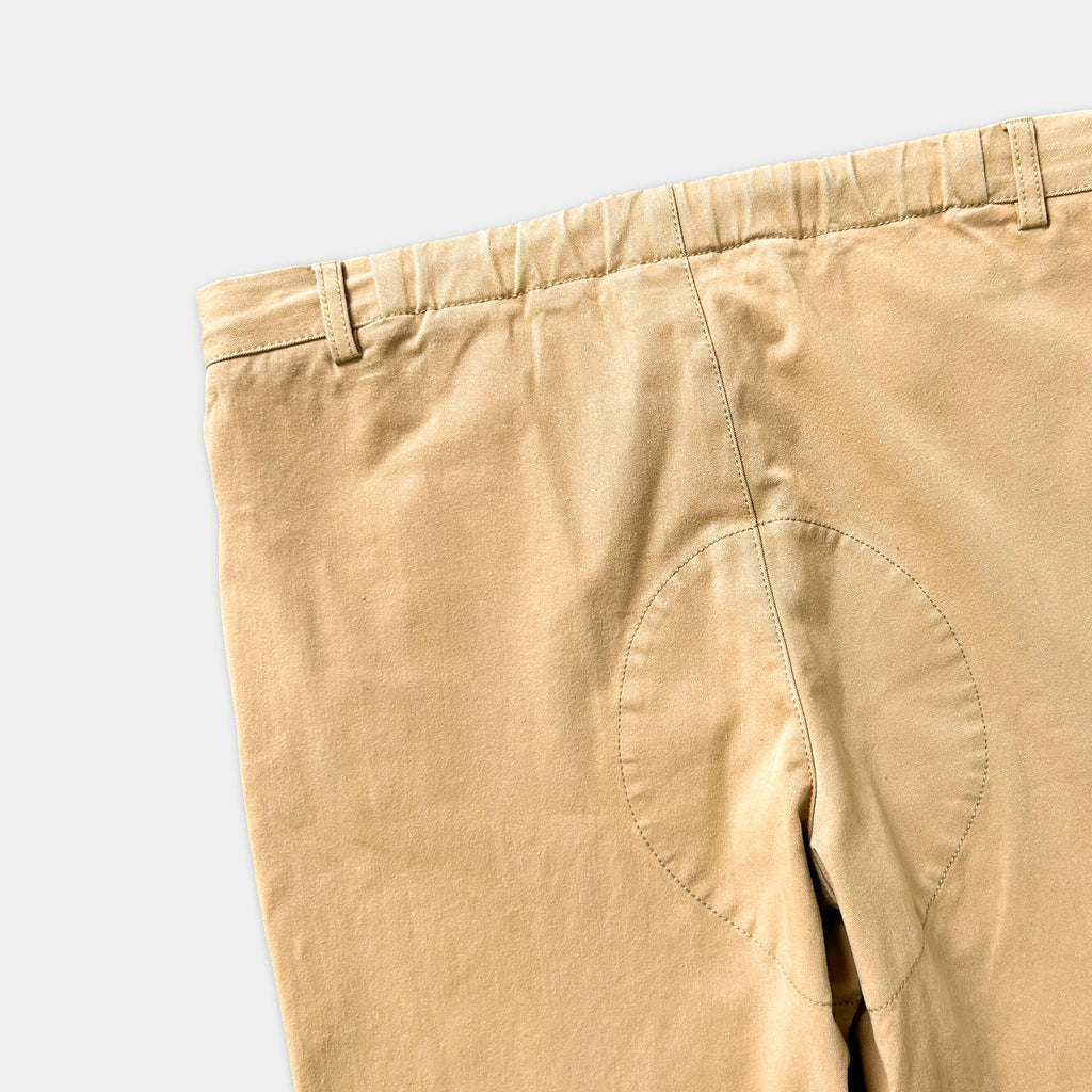 A pair of khaki pants with a small circular hole in the center.