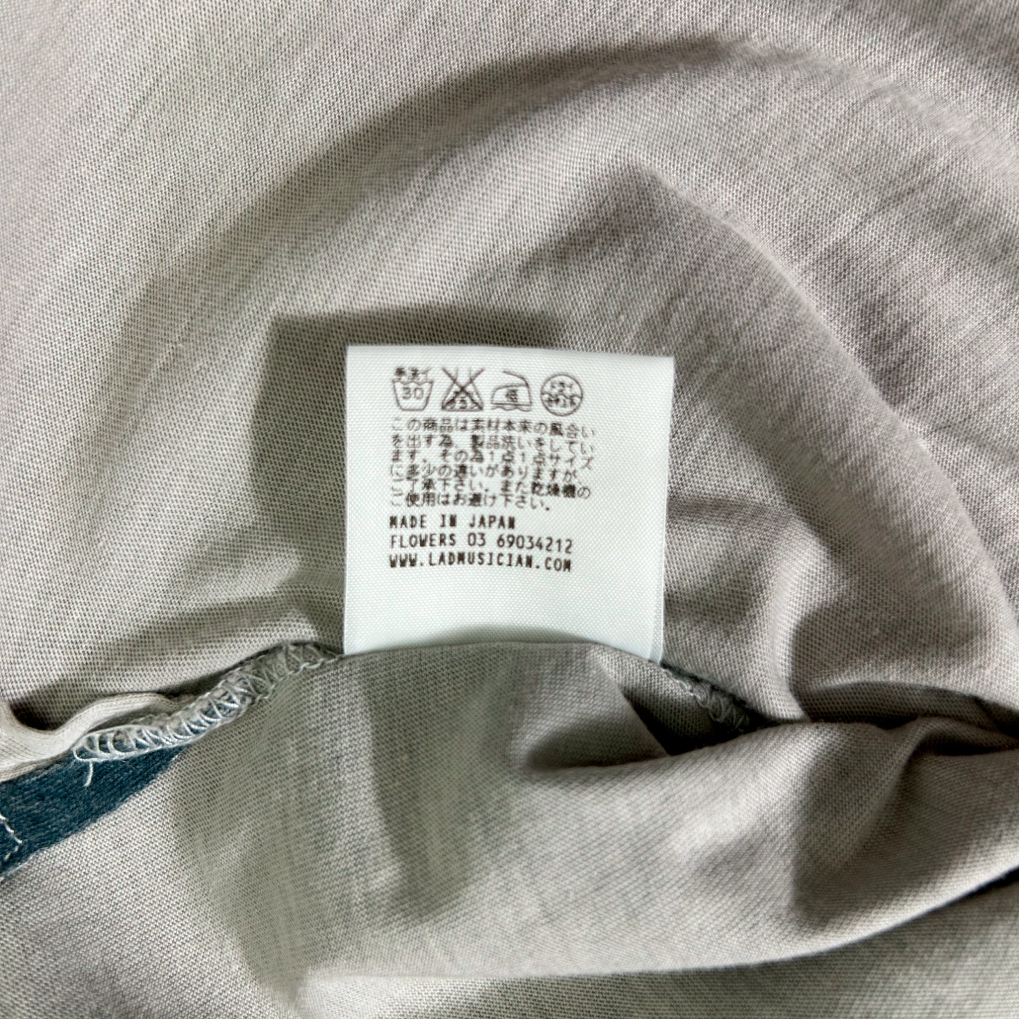 a close-up view of a white label with text and symbols on a fabric surface.