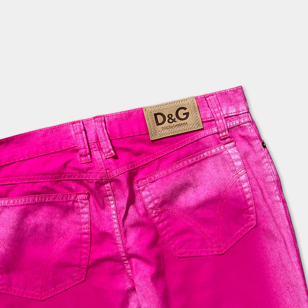 A pair of bright pink, shiny denim jeans with a D&G logo on the back pocket.