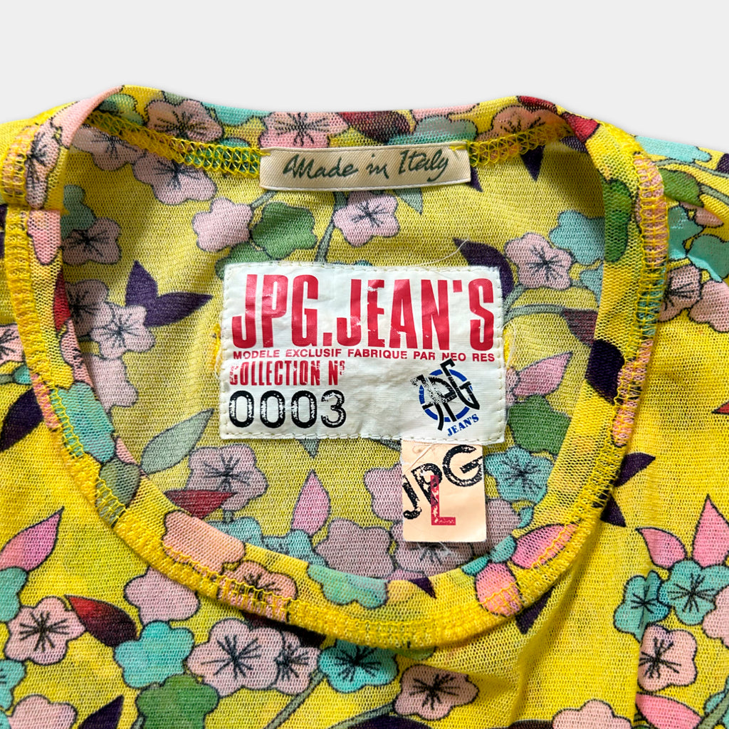 a yellow floral print shirt with a label on the collar, indicating that it is a handmade item from Italy.